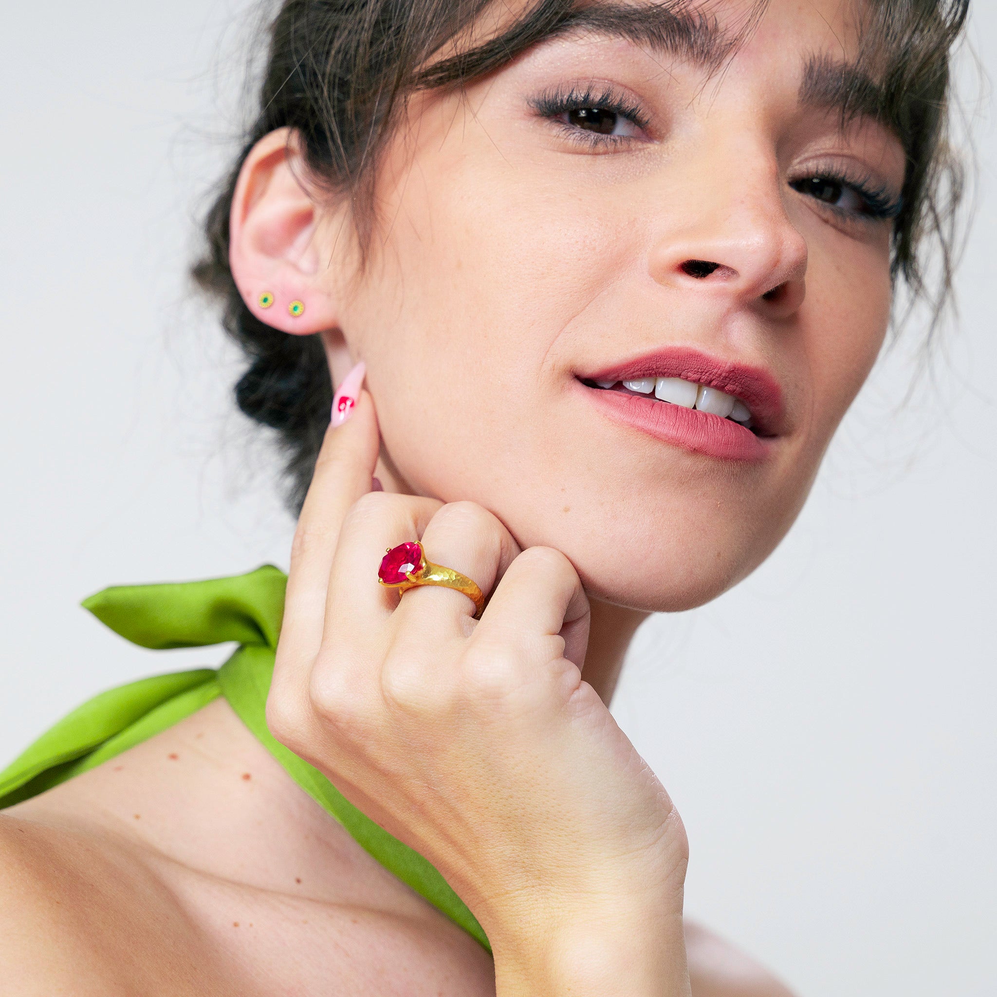 Model displaying an 18k Gold ring featuring four stems holding an elliptic Ruby, combining rich color depth with a dignified presence.