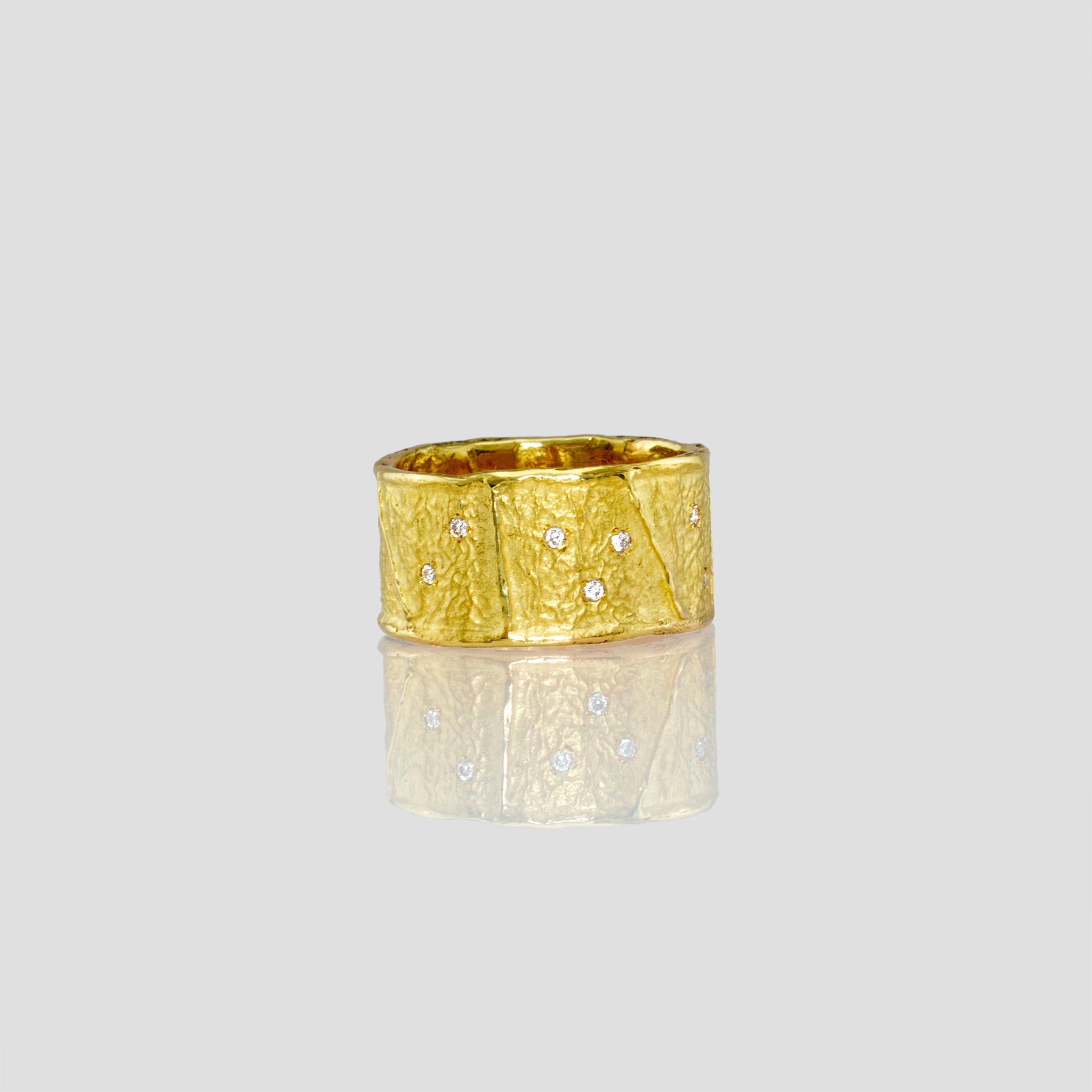 A stunning 18k Yellow Gold Ring featuring a unique wrinkled texture inspired by ancient Egyptian artistry, elegantly adorned with tiny sparkling diamonds for a timeless charm.