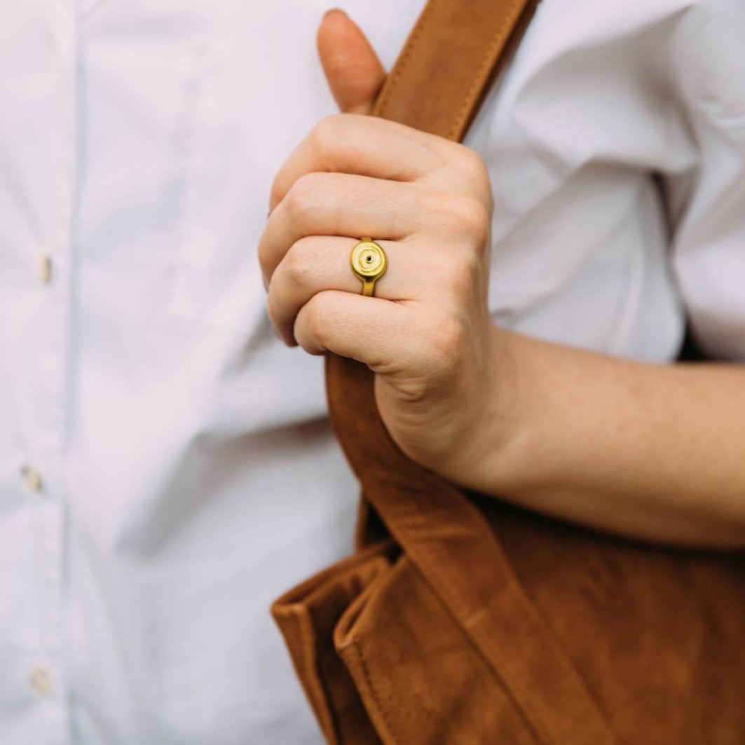 Handmade 18k Gold ring with a central Emerald, on a model's hand, exuding vintage charm reminiscent of the Egyptian pharaohs' era.