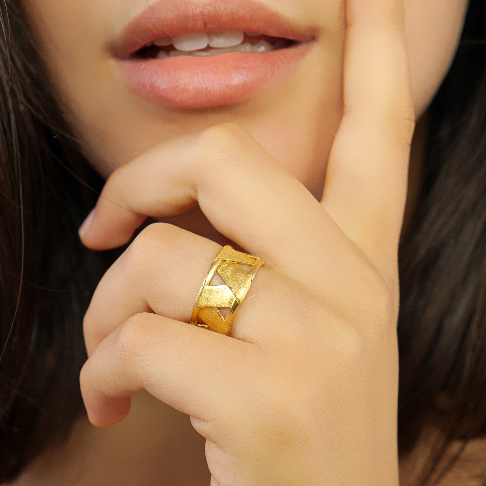 A close up on a model of a Unique Yellow Gold Braided Ring fashioned in the shape of a drum, offering both boldness and comfort with its lightweight design.