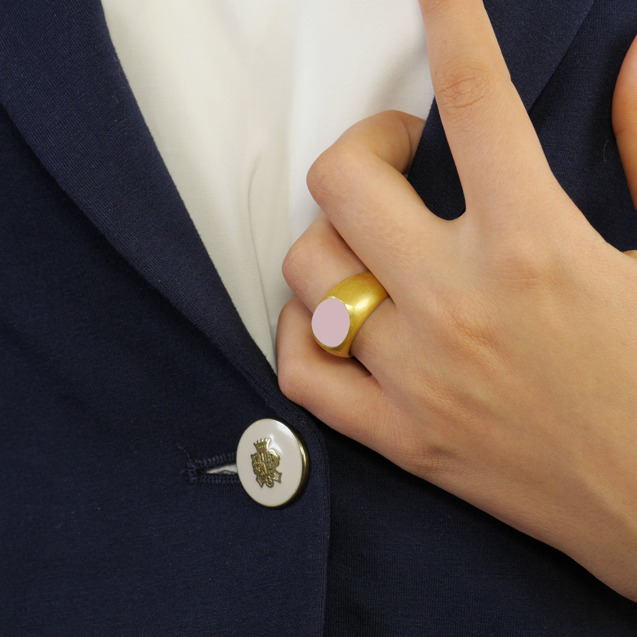 A timeless gold oval ring adorned with a captivating Rose Quartz gemstone on a model's hand. This classic piece exudes traditional elegance and is beloved for its enduring appeal.
