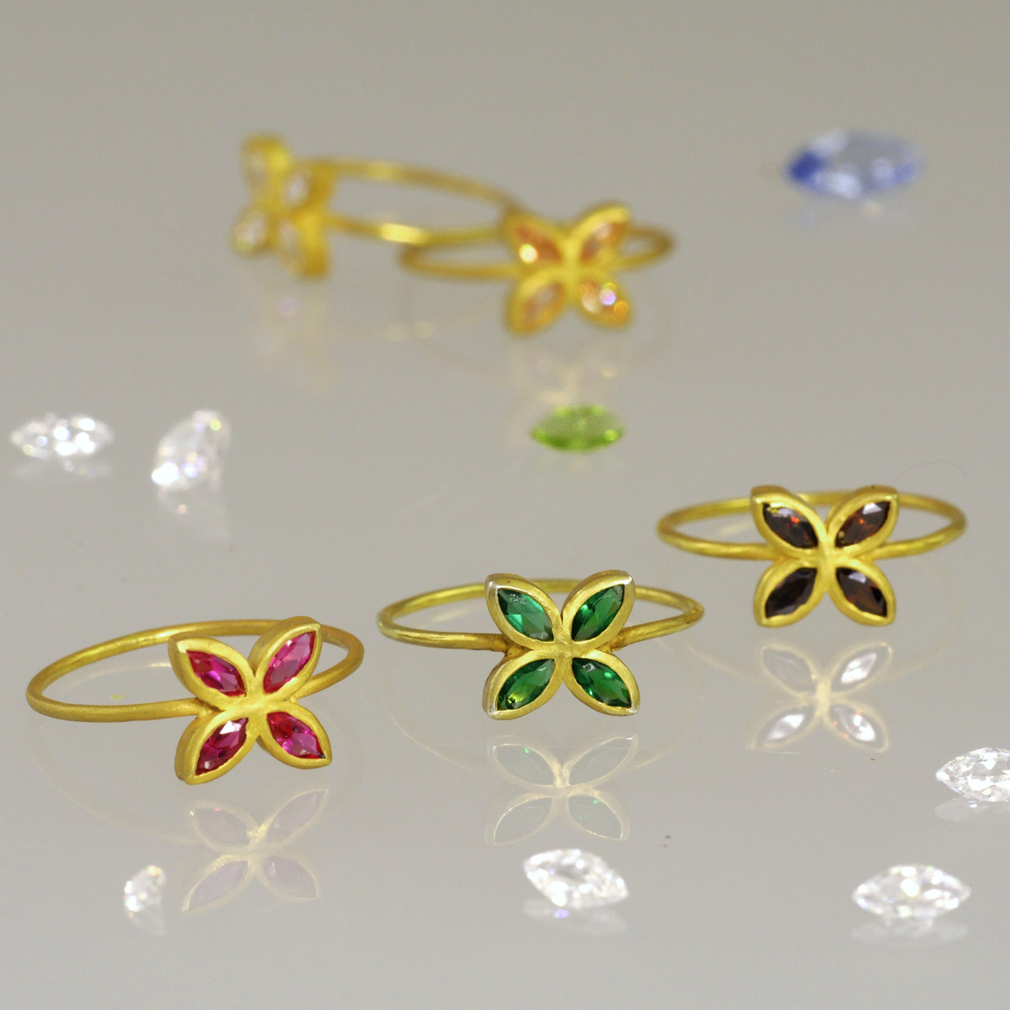 18k Gold Marquee Gold rings arranged on a shiny surface, surrounded by sparkling diamonds.