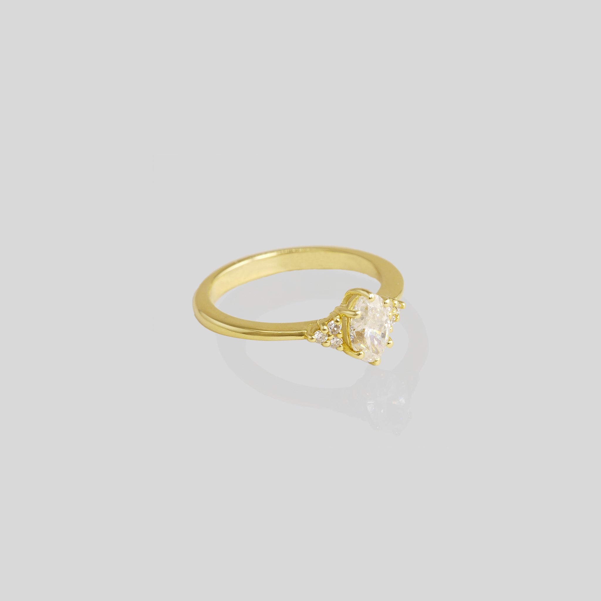 Enhance your proposal with our timeless Classic Gold Engagement Ring. Delicately designed with an oval diamond surrounded by six smaller diamonds, it exudes elegance and charm, symbolizing everlasting love.