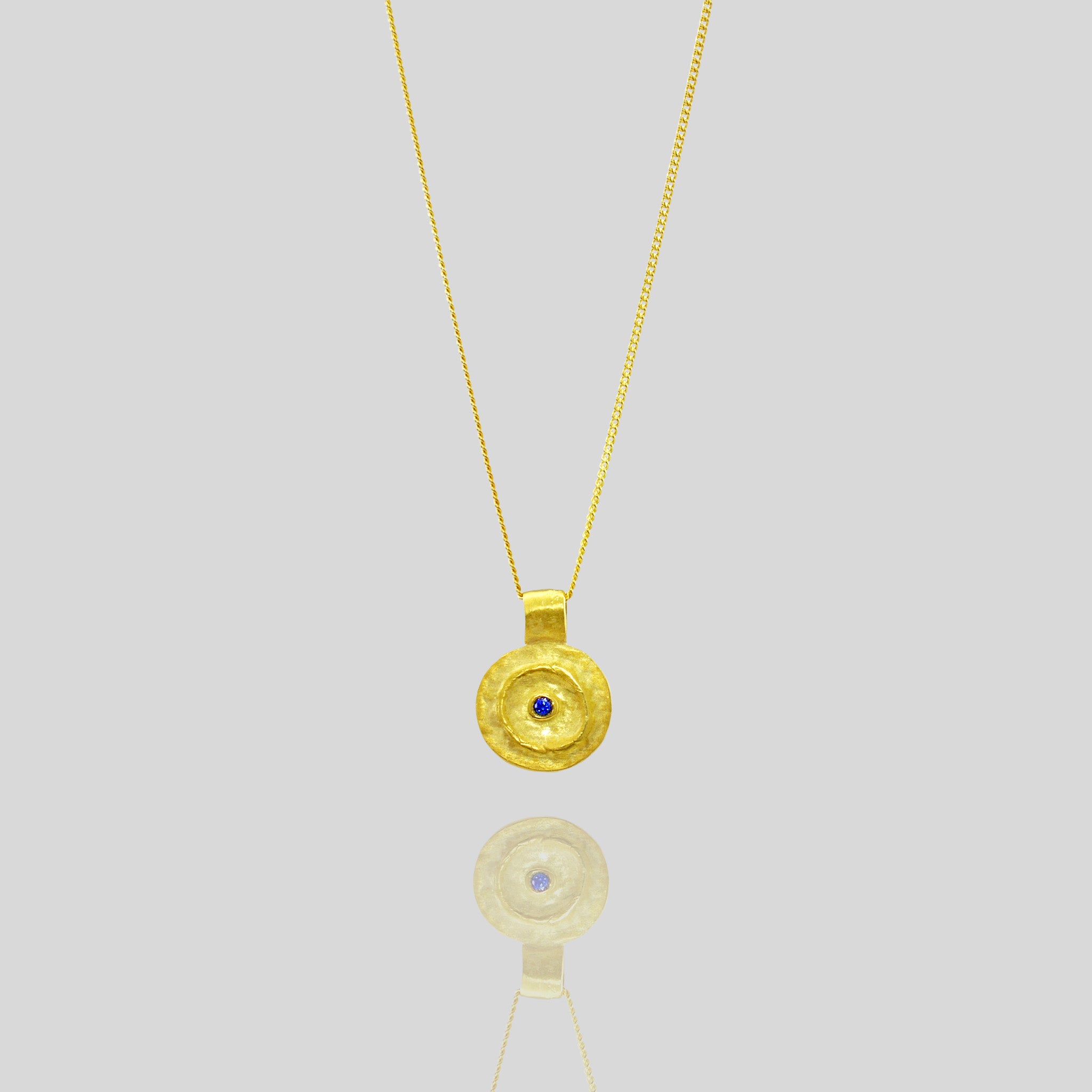 Pharaohs I - Ancient round gold pendant with a vivid Sapphire gemstone at its center, reminiscent of the opulent jewelry of the Egyptian Pharaohs' era, crafted from yellow gold.