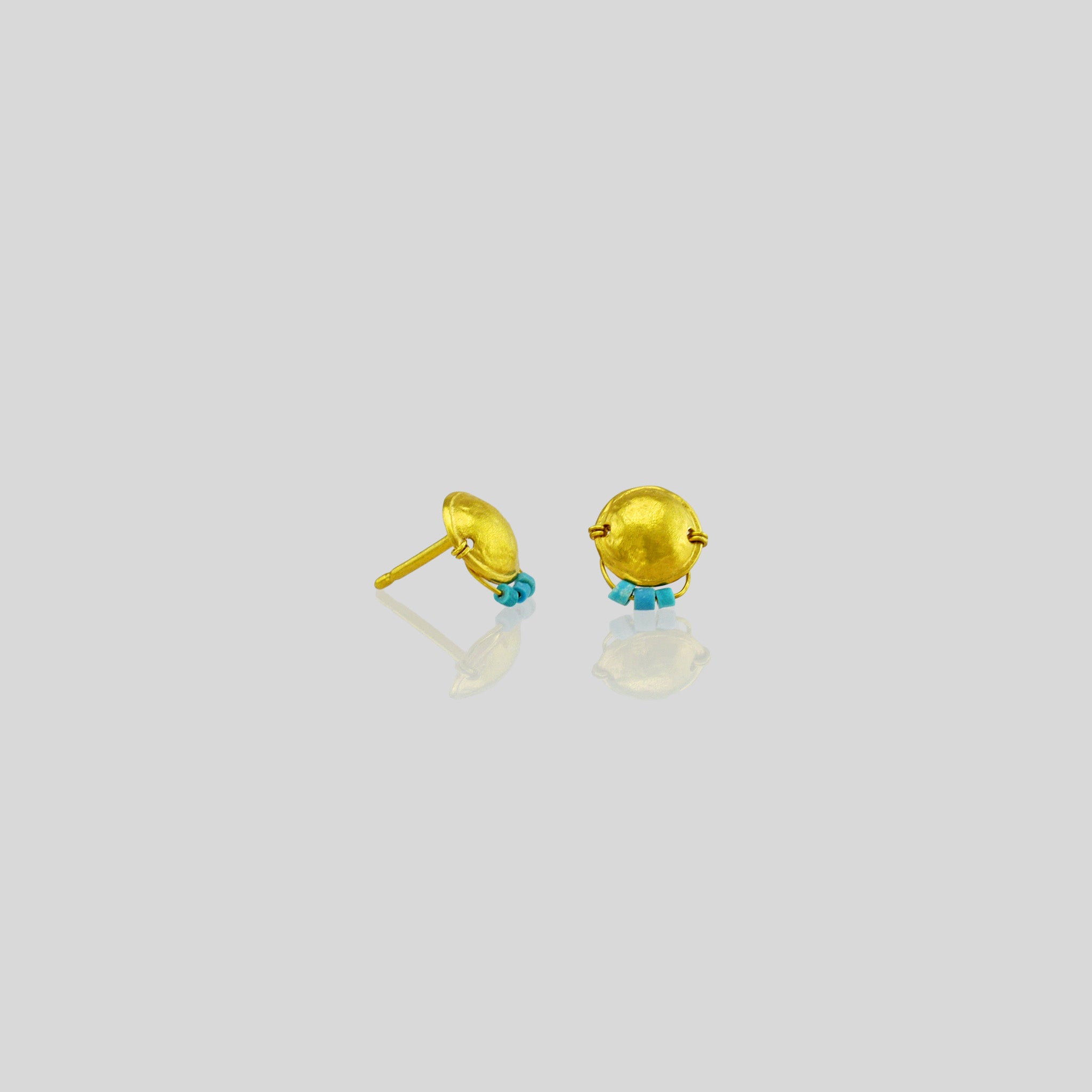 Handmade gold stud earrings featuring an arched disk adorned with a golden thread and tiny turquoise beads hanging on a golden bow.