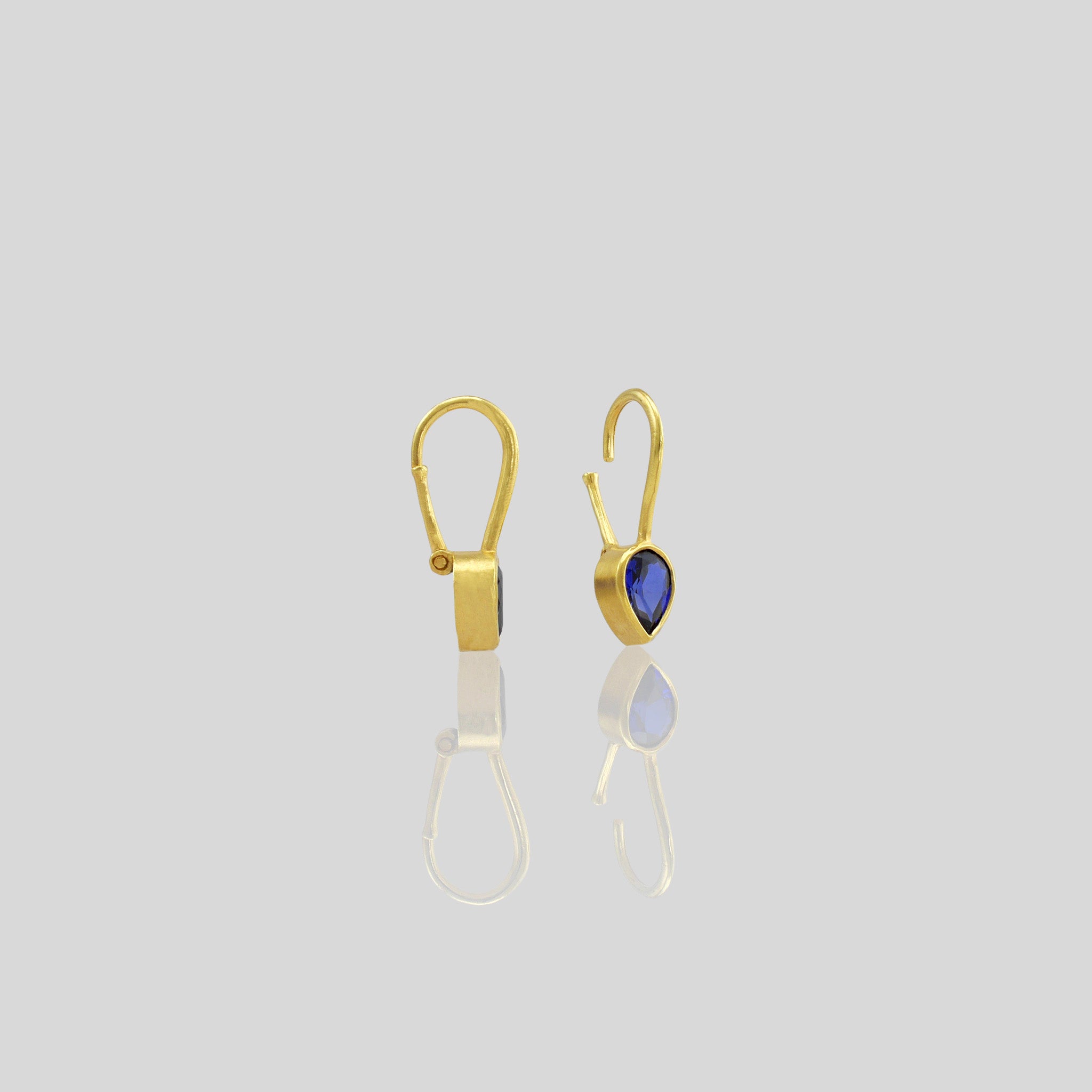 Lightweight gold earrings featuring a drop-shaped Sapphire gemstone and promote spiritual harmony