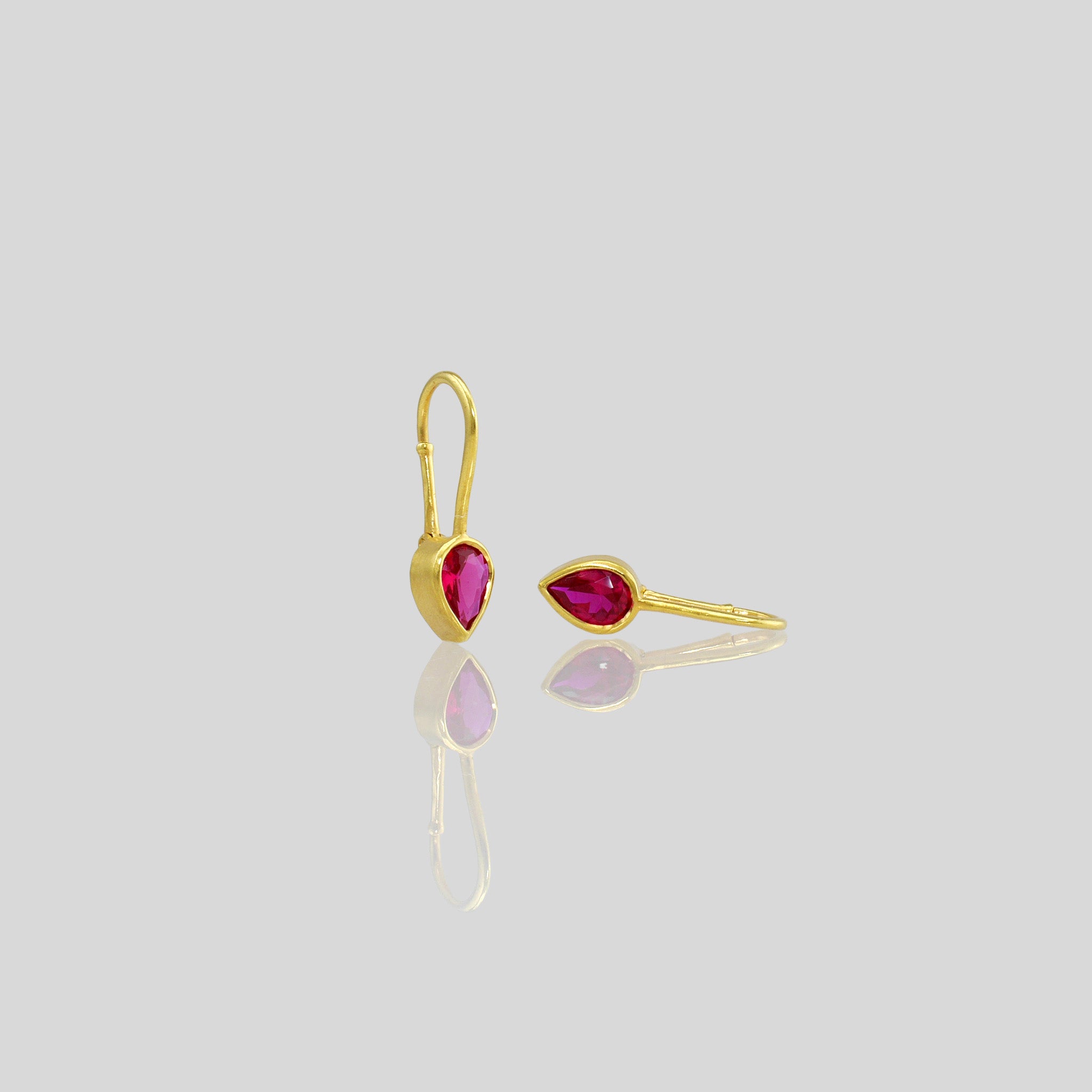 Lightweight gold earrings featuring a drop-shaped Ruby gemstone and promote spiritual harmony