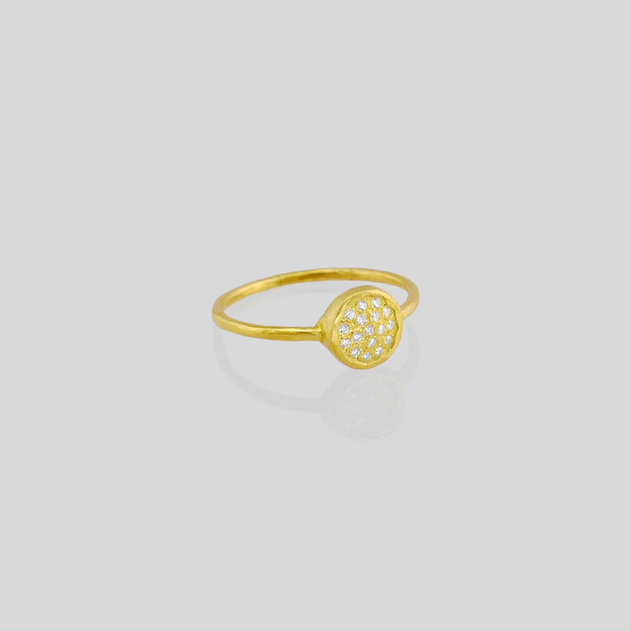 Delicate hand-made 18k Gold ring with a circular plate set with tiny Diamonds. The sparkle from the stones resembles a starry night.