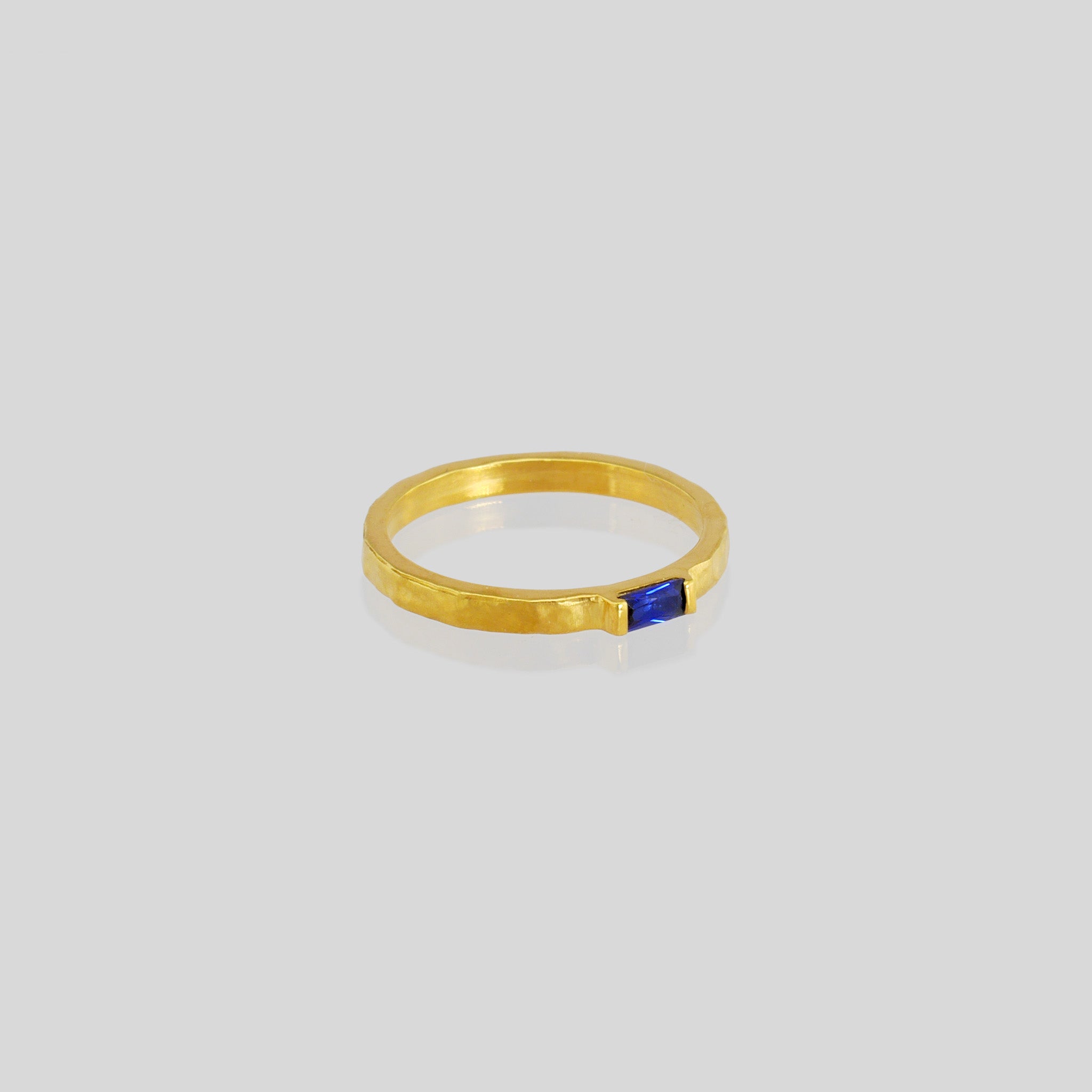 Handmade gold ring with hand-hammered surface and baguette Sapphire accent. Timeless elegance in Yellow gold, a perfect addition to any ensemble.