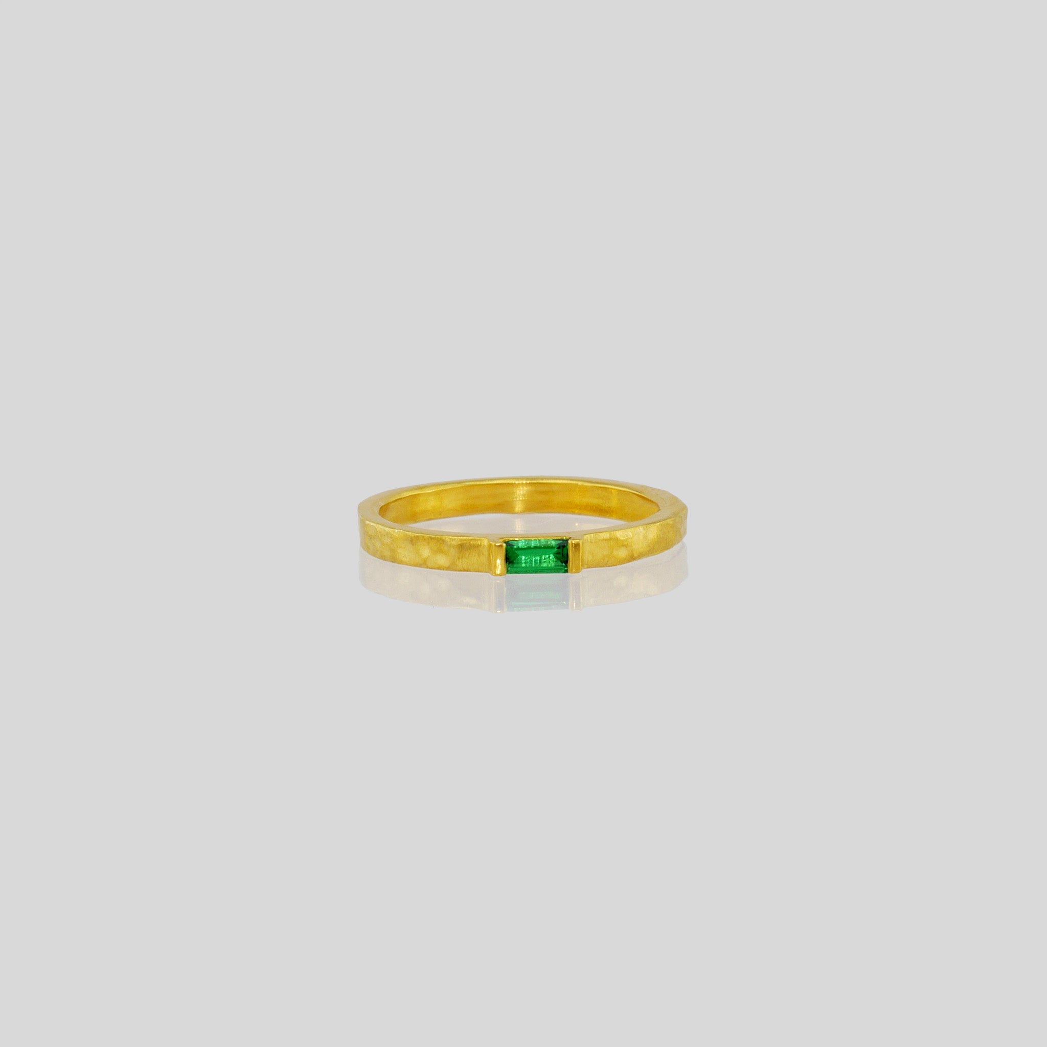 Handmade gold ring with hand-hammered surface and baguette Emerald accent. Timeless elegance in Yellow gold, a perfect addition to any ensemble.