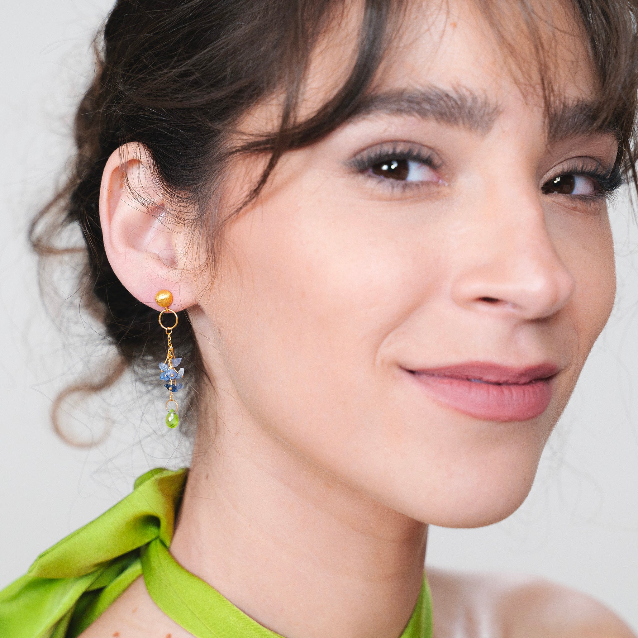Timeless elegance meets luxury in these Yellow Gold earrings adorned with raw blue sapphires and a dangling Peridot drop.