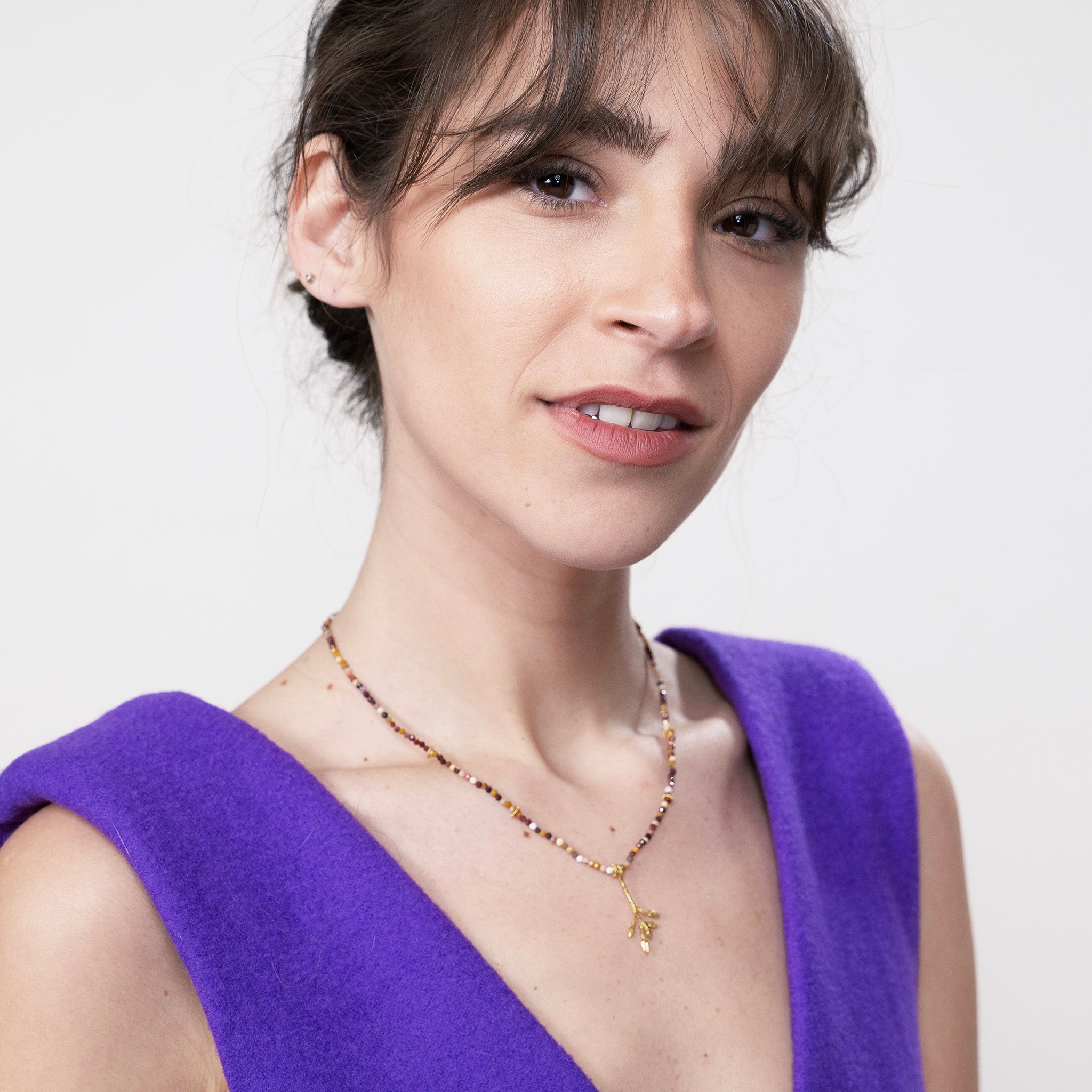 Model wearing a delicate yellow gold branch pendant, with Jasper stone string, showcasing the natural elegance and vibrancy of the piece.