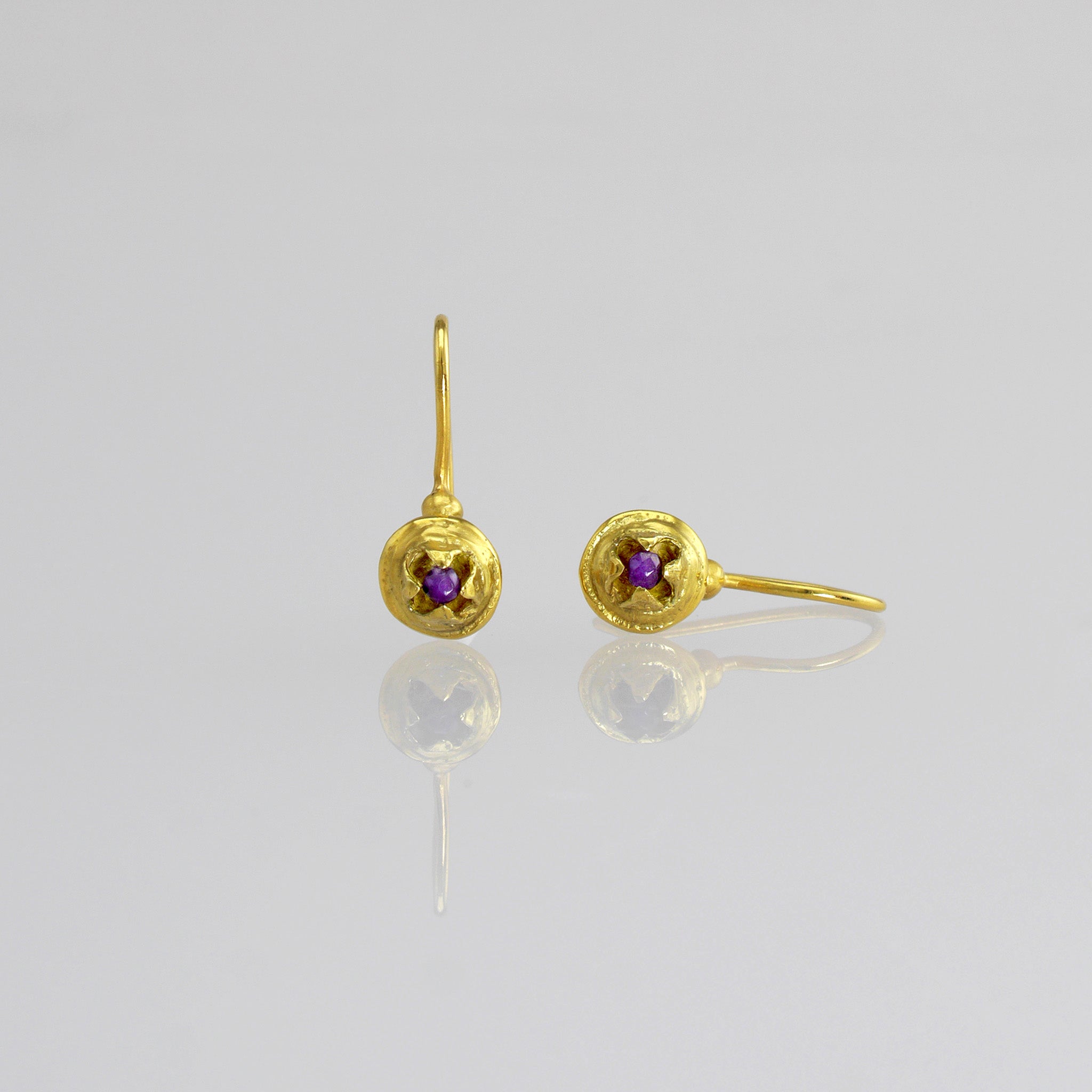 Delicate drop earrings in yellow gold, inspired by eucalyptus seeds, featuring a central inlaid amethyst stone symbolizing a seed ready to hatch.