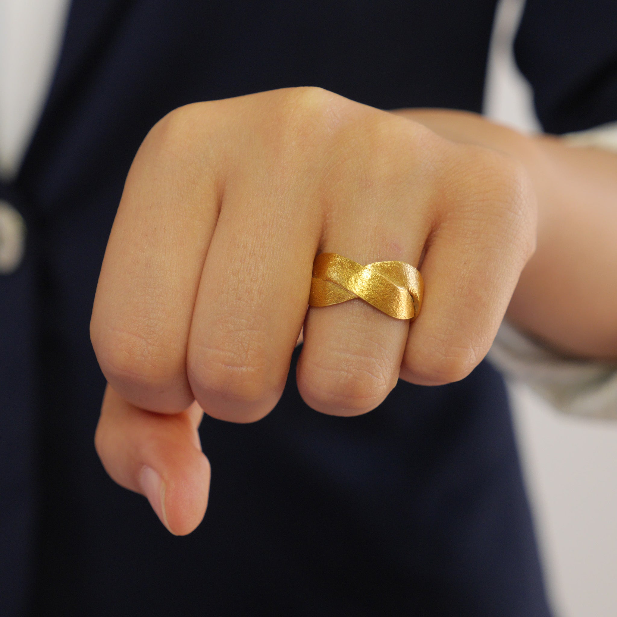 Close up on a model of our Handmade 18k Gold ring with braided bands, offering an elegant and versatile addition to both everyday wear and special occasions. A timeless classic with a unique twist.
