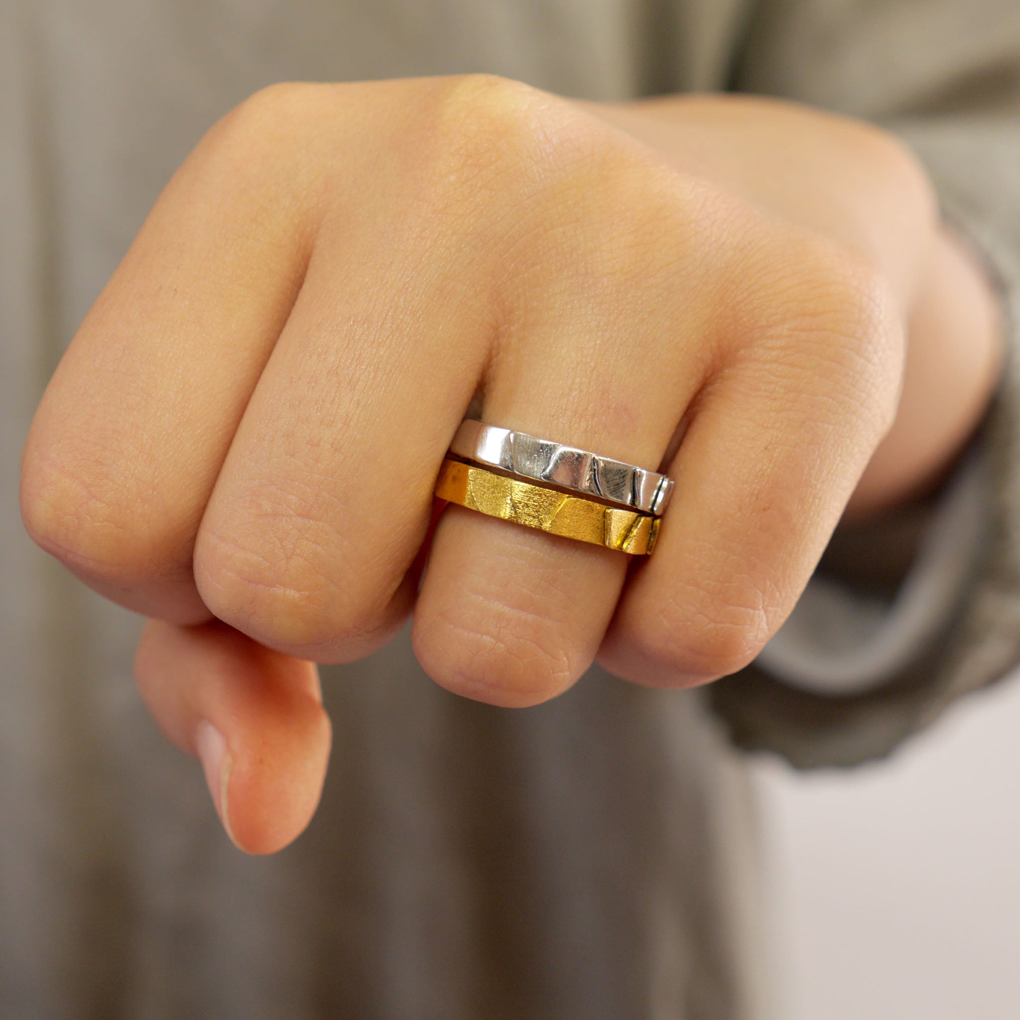 Two 18k Yellow and White gold narrow layered rings on a model's finger. 