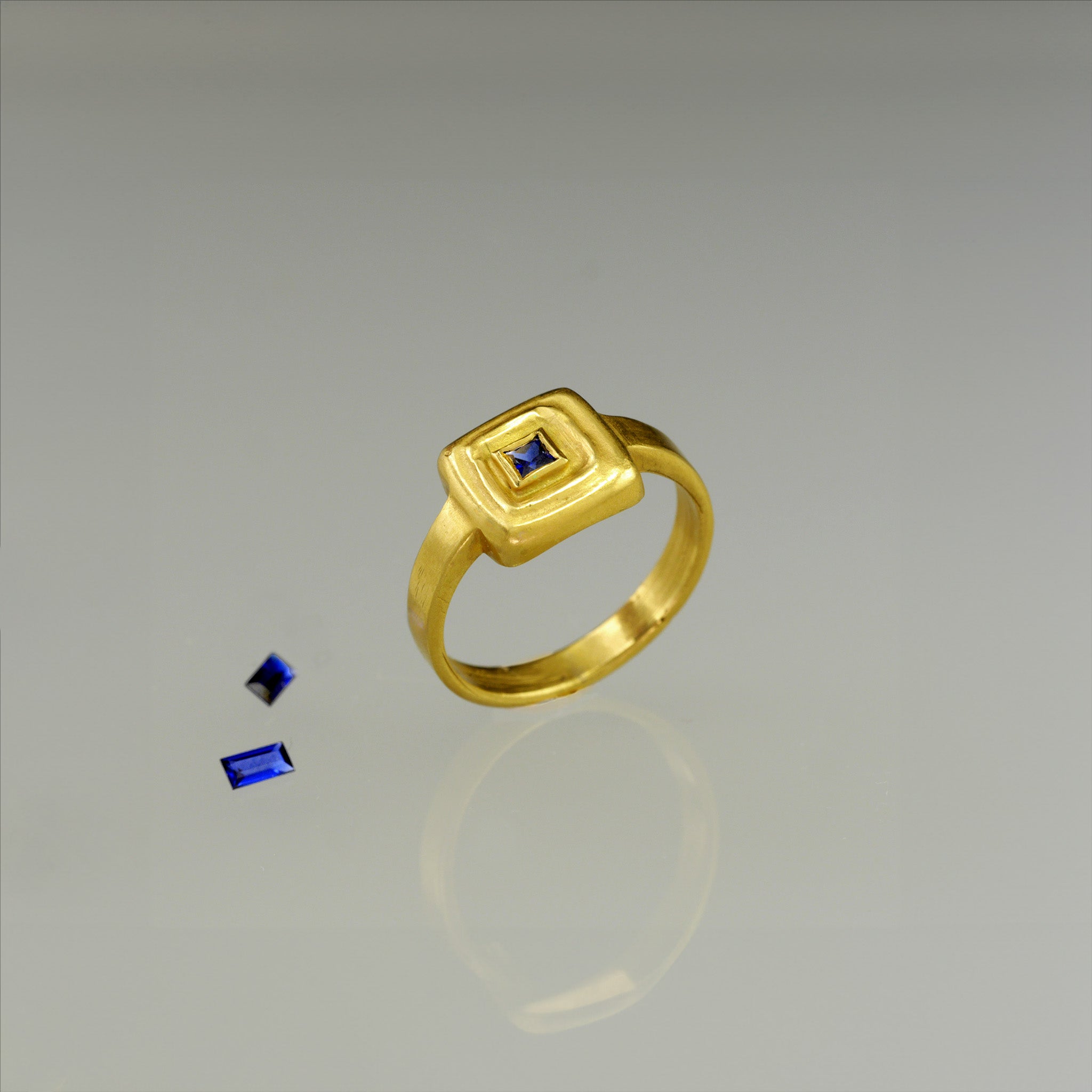 Top view of Handcrafted 18k Gold ring featuring a square Ruby set atop a square surface, evoking the ancient Egyptian era's golden jewelry of the Pharaohs.