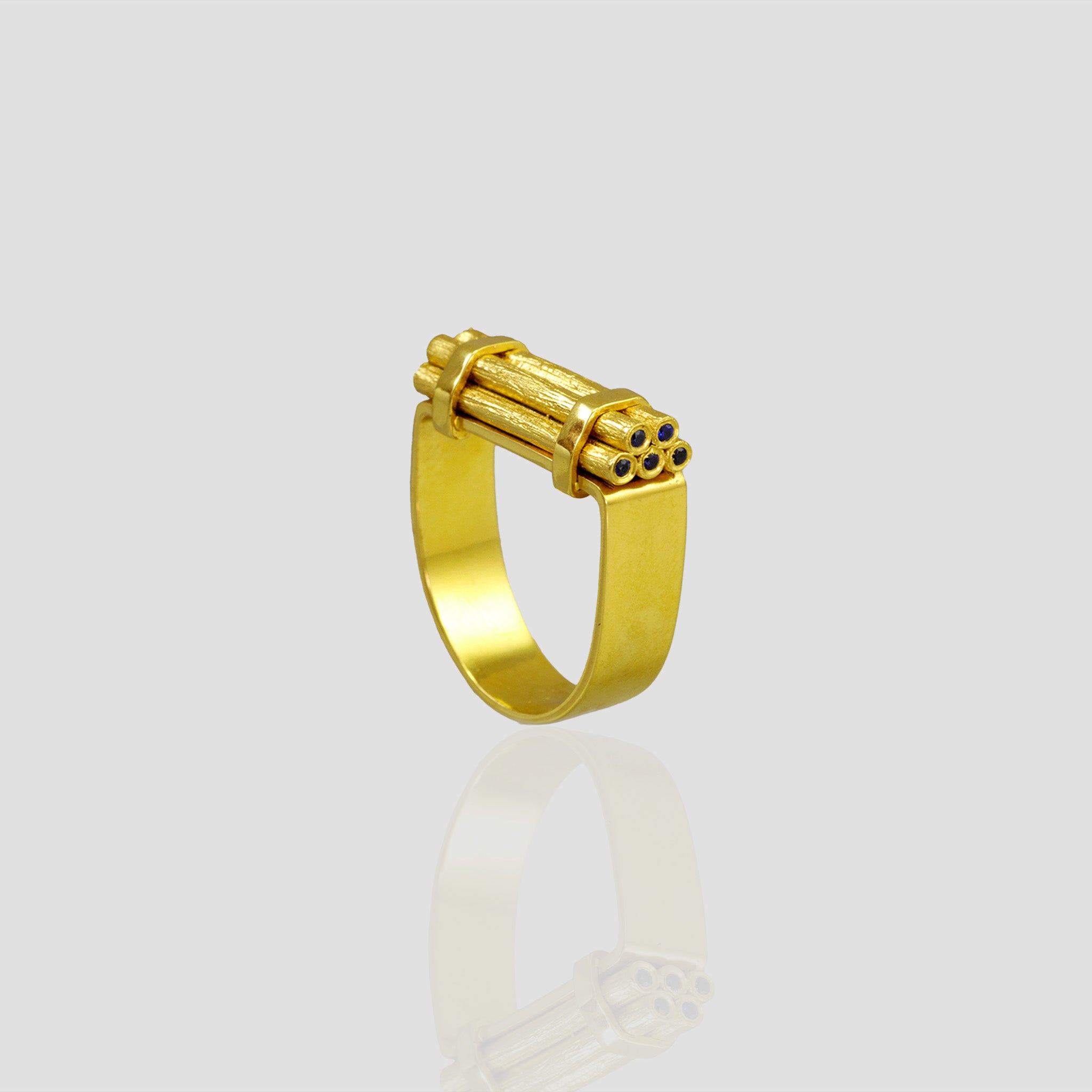Handcrafted gold ring with stacked wood-inspired design, adorned with sparkling Sapphires for added color and radiance. Contemporary and comfortable statement piece.