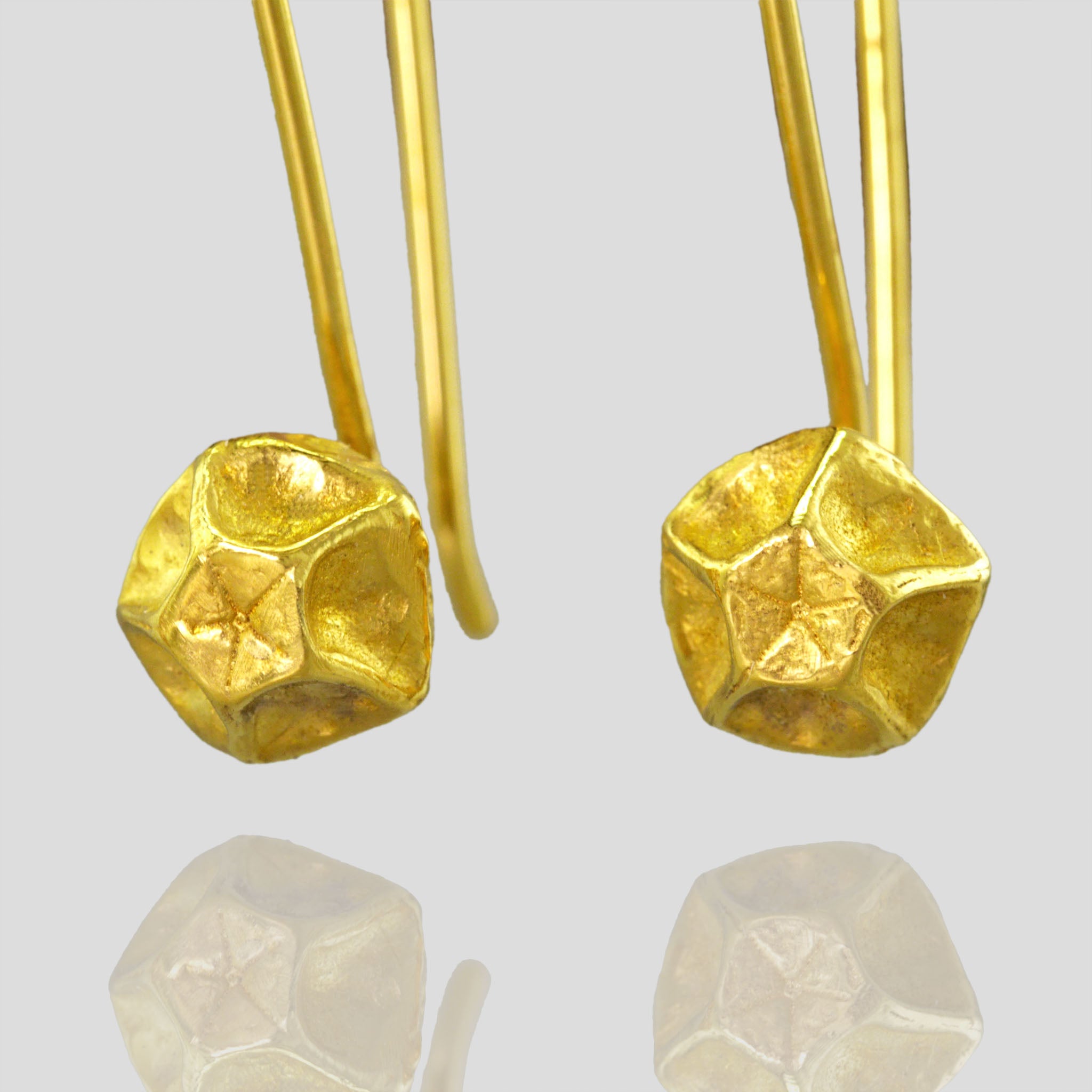 Close up of handcrafted Gold Pentagon Earrings with Intricate Lines