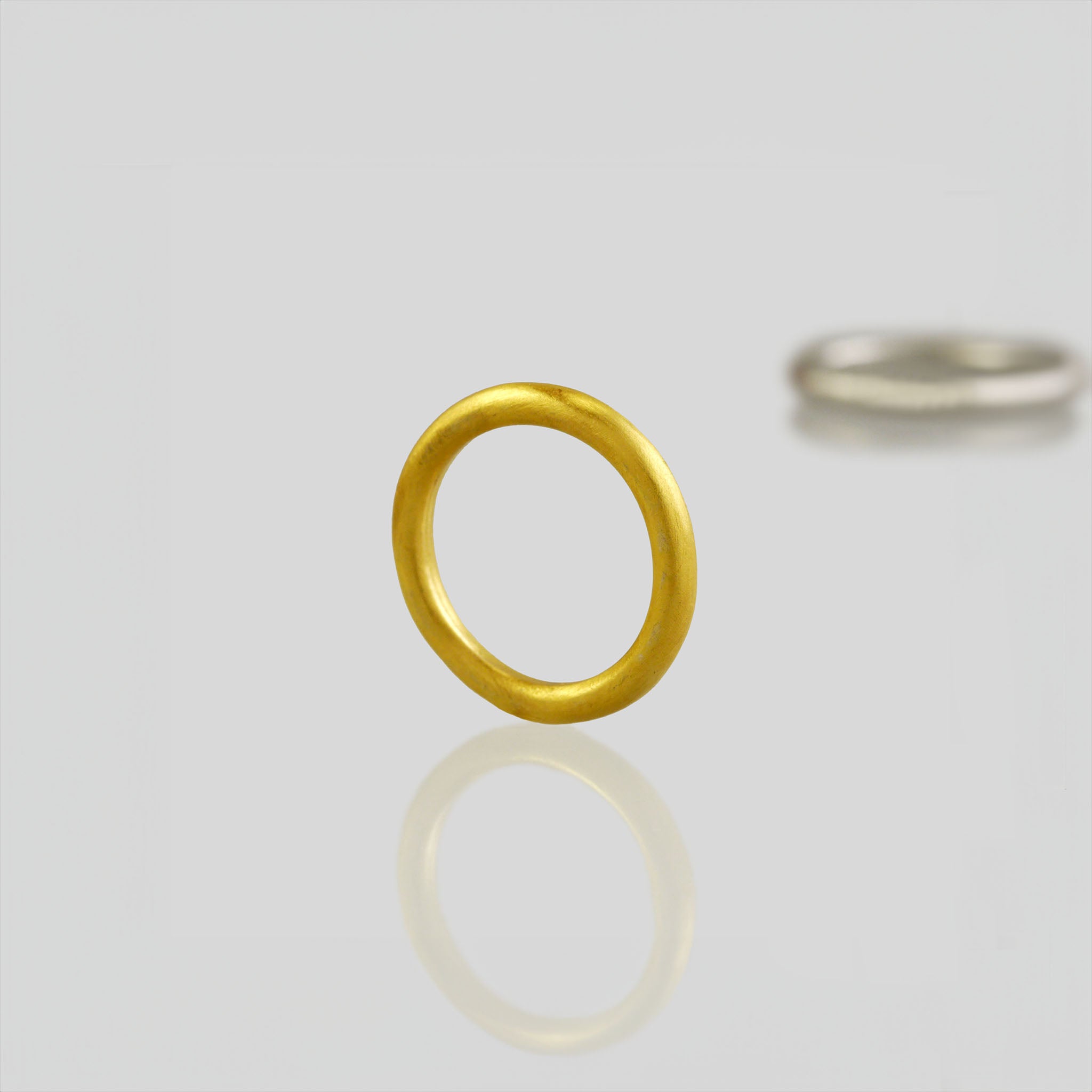 Round profile yellow gold wedding ring with minimalist design, perfect for your special occasion.