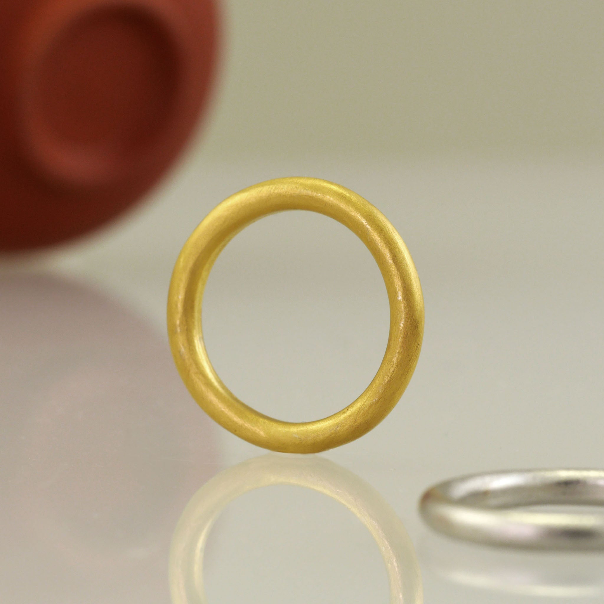 Close up of Round profile yellow gold wedding ring with minimalist design, perfect for your special occasion.
