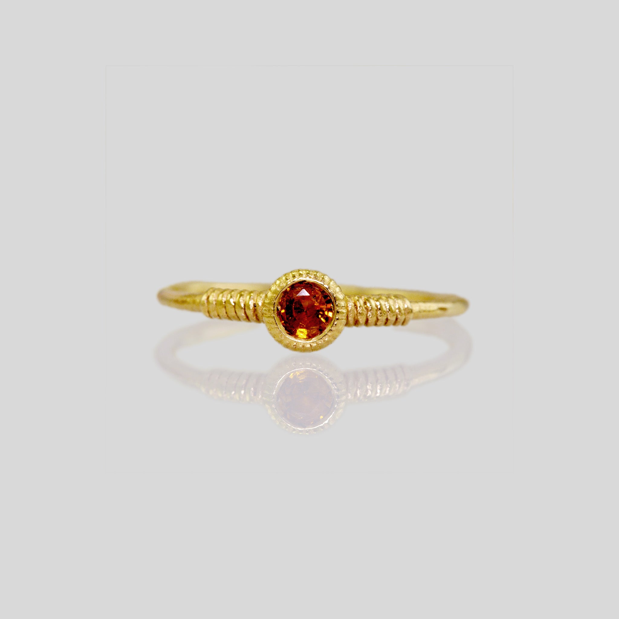 Front view of delicate gold coiled ring adorned with Citrine gemstone, showcasing its elegant coiled design.