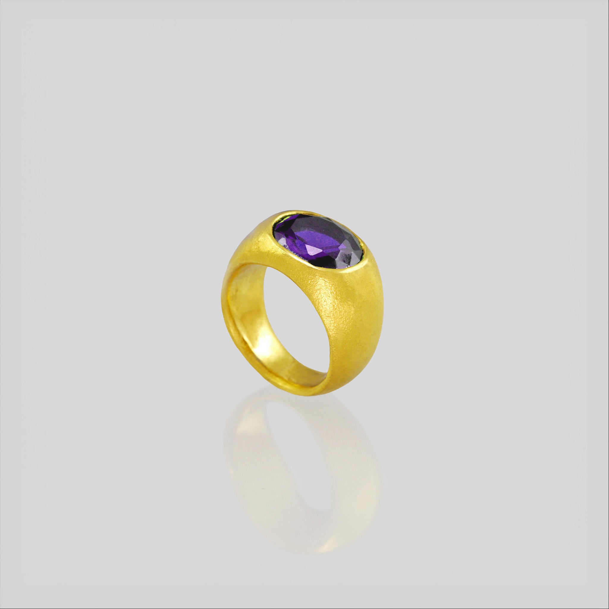 A timeless 18k Gold oval ring adorned with a captivating amethyst gemstone. This classic piece exudes traditional elegance and is beloved for its enduring appeal.