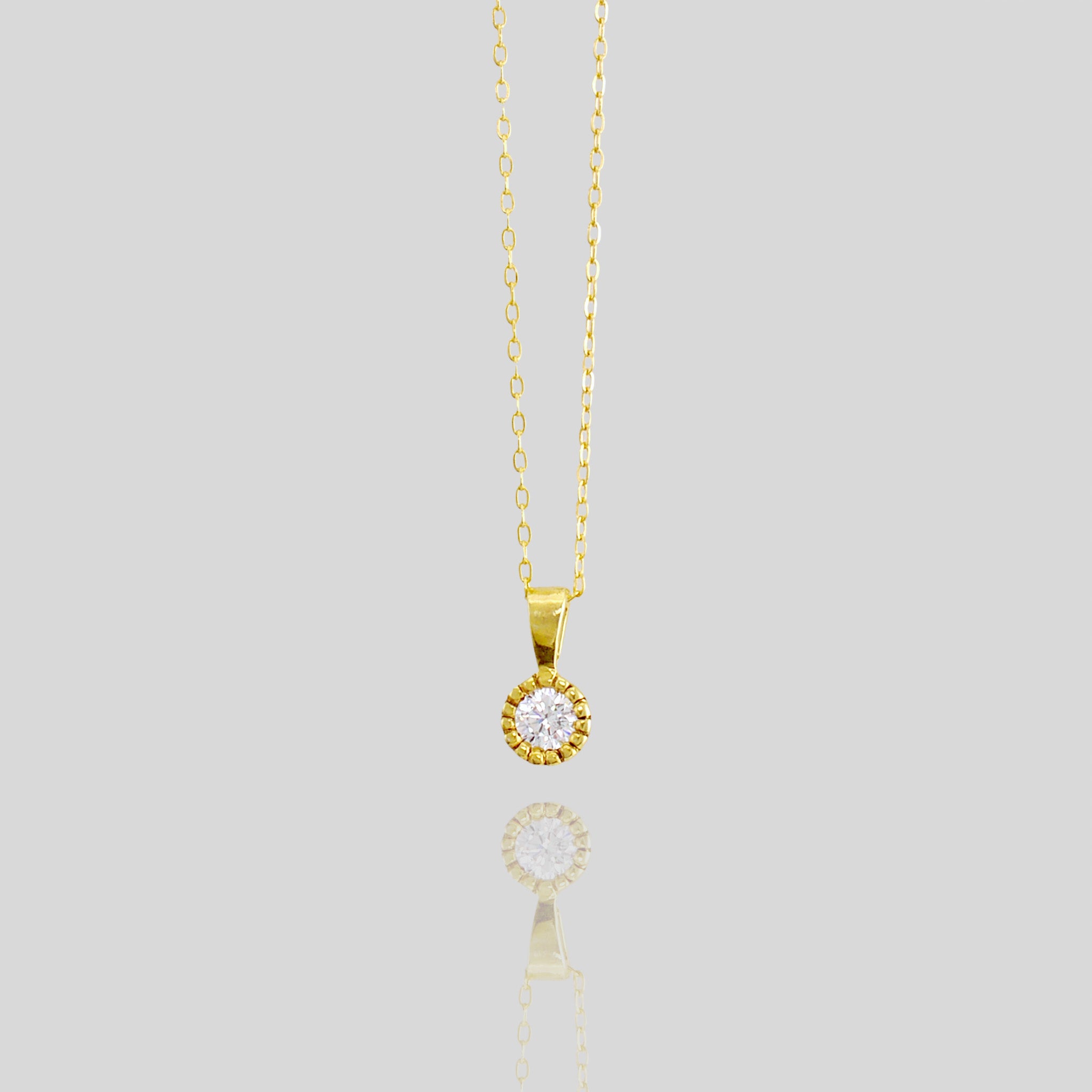 Close up of an Elegant round gold pendant with embroidered texture and central diamond, exuding classic sophistication.