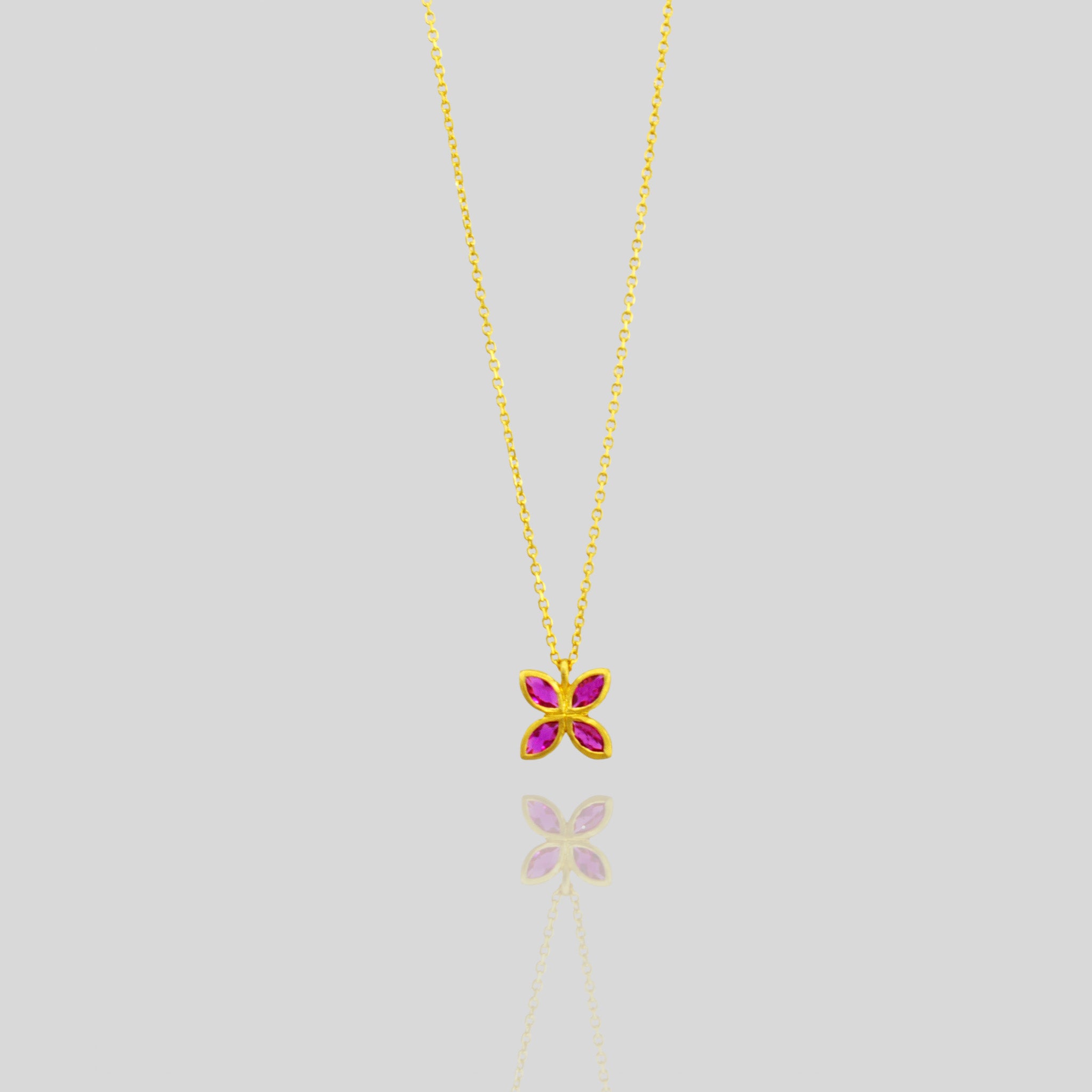 Elegant gold pendant with four marquise-cut Rubies arranged into a delicate flower design, offering luxury and beauty suitable for any gift occasion.