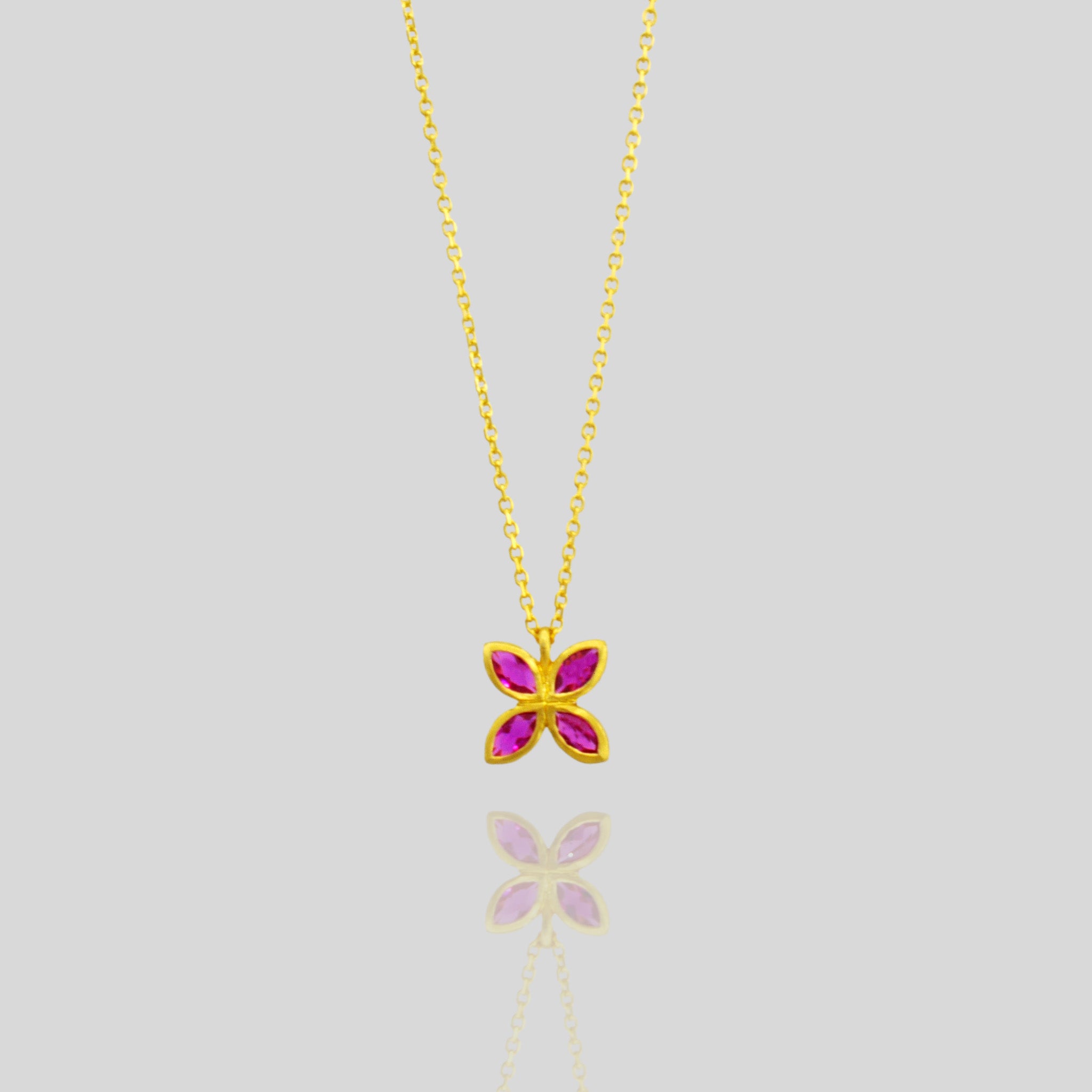 Close up of an Elegant gold pendant with four marquise-cut Rubies arranged into a delicate flower design, offering luxury and beauty suitable for any gift occasion.