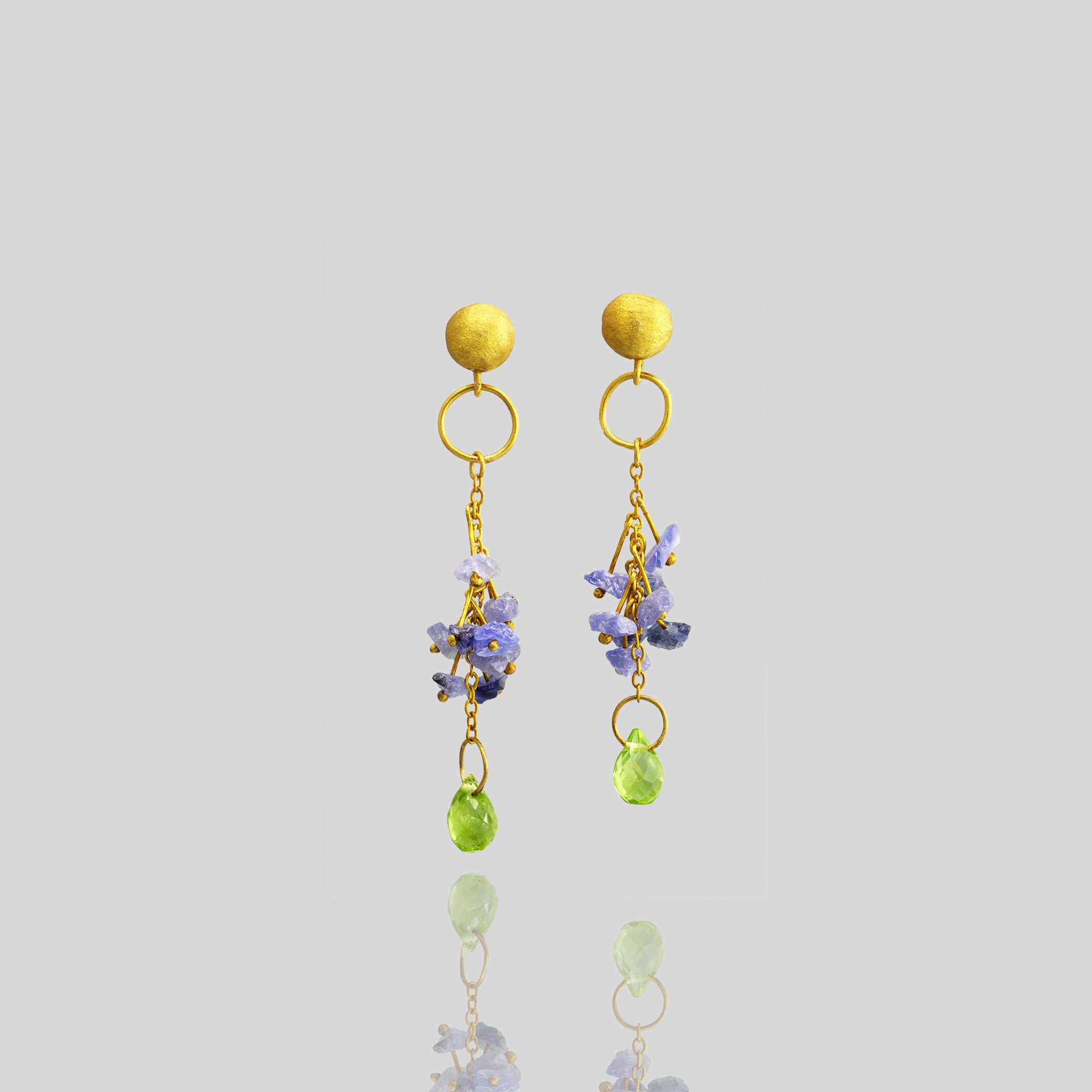 Timeless elegance meets luxury in these Yellow Gold earrings adorned with raw blue sapphires and a dangling Peridot drop.