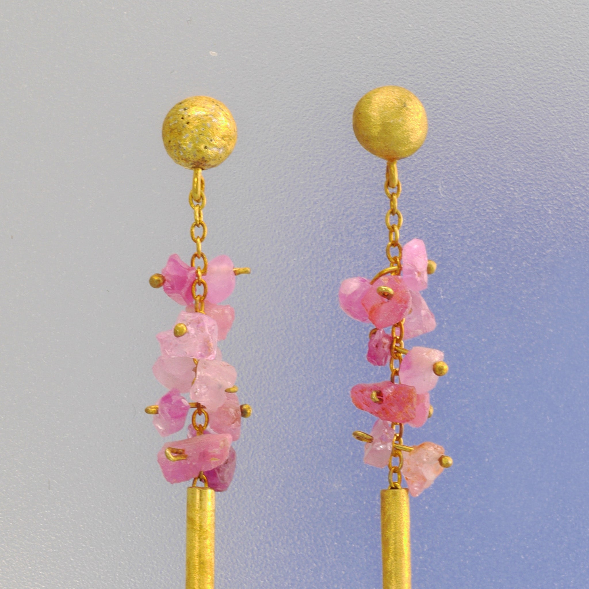 Close up of Venus Earrings with raw pink Sapphires and Carnelian gemstone drop, exuding timeless elegance and luxury.