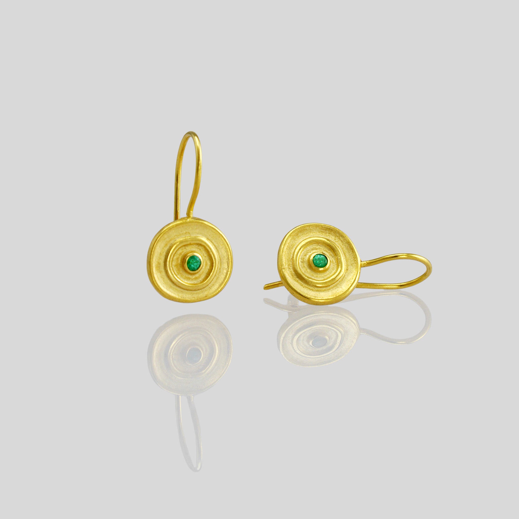 close up of Hand-made 18k gold round drop earrings with a central Emerald gemstone, inspired by ancient Egyptian Pharaohs' gold jewelry.
