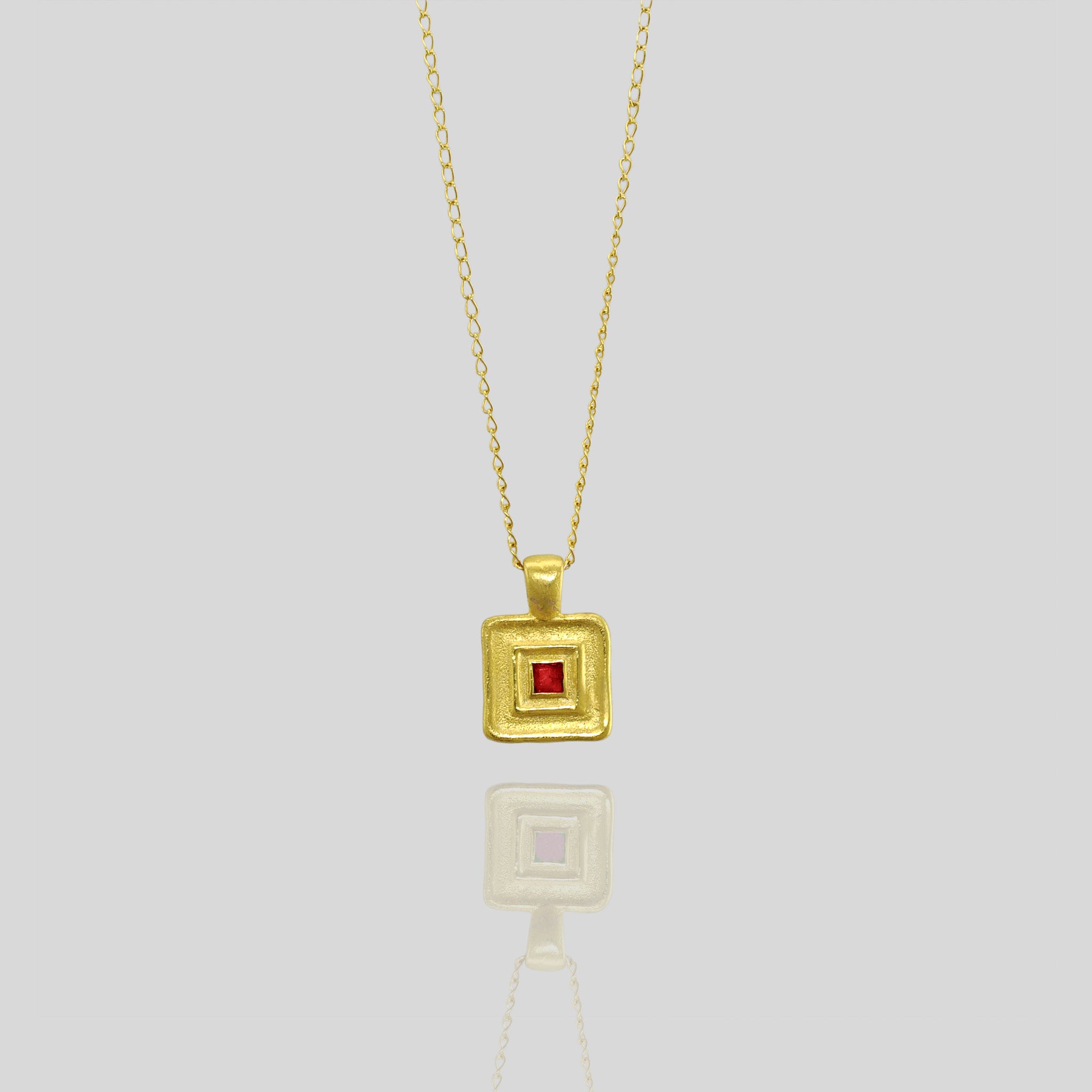 Handmade square gold pendant featuring a square Ruby gemstone at its heart, crafted from Yellow Gold to mirror the majestic jewelry of ancient Egyptian Pharaohs.