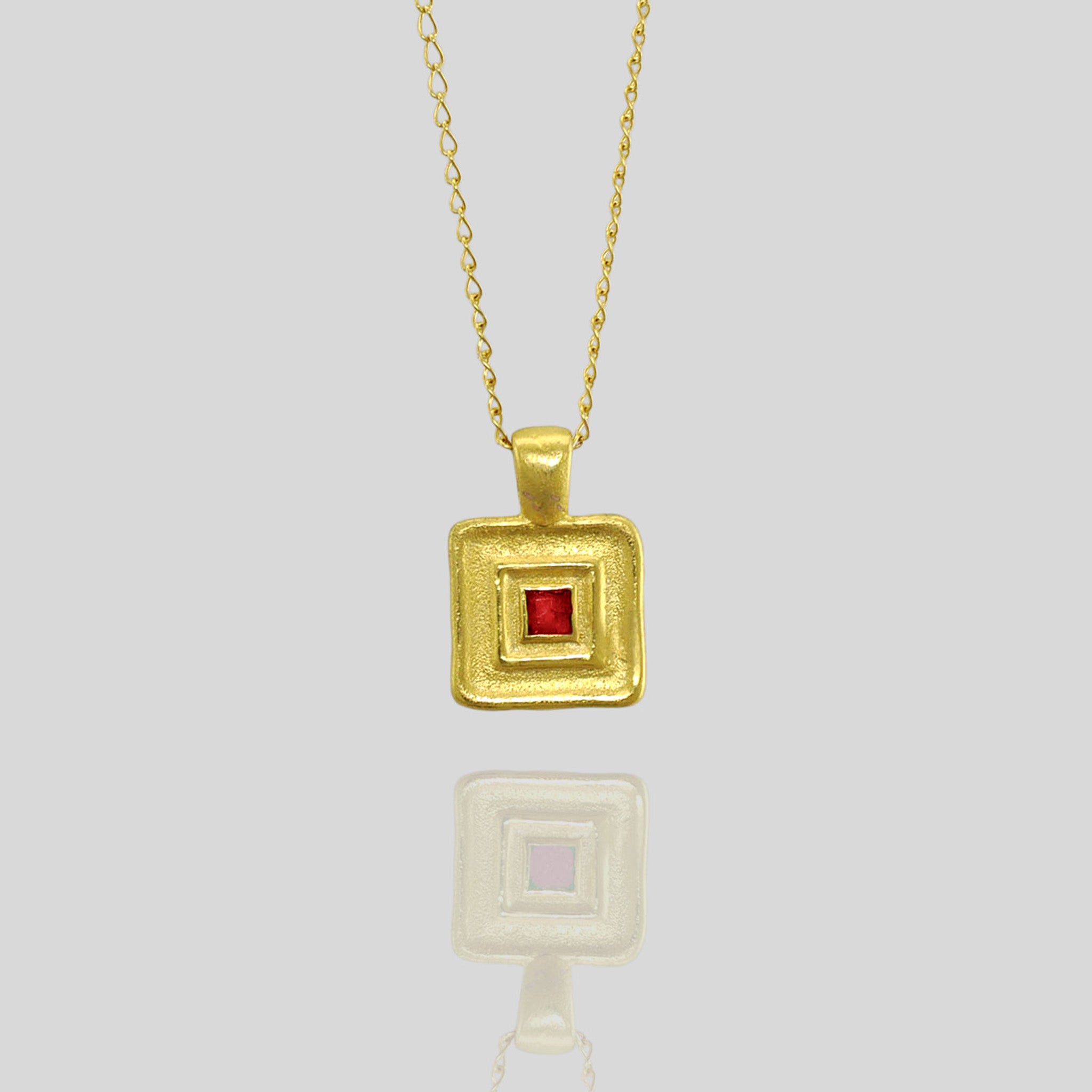 Detail of Handmade square gold pendant featuring a striking square Ruby gemstone at its heart, crafted from Yellow Gold to mirror the majestic jewelry of ancient Egyptian Pharaohs.