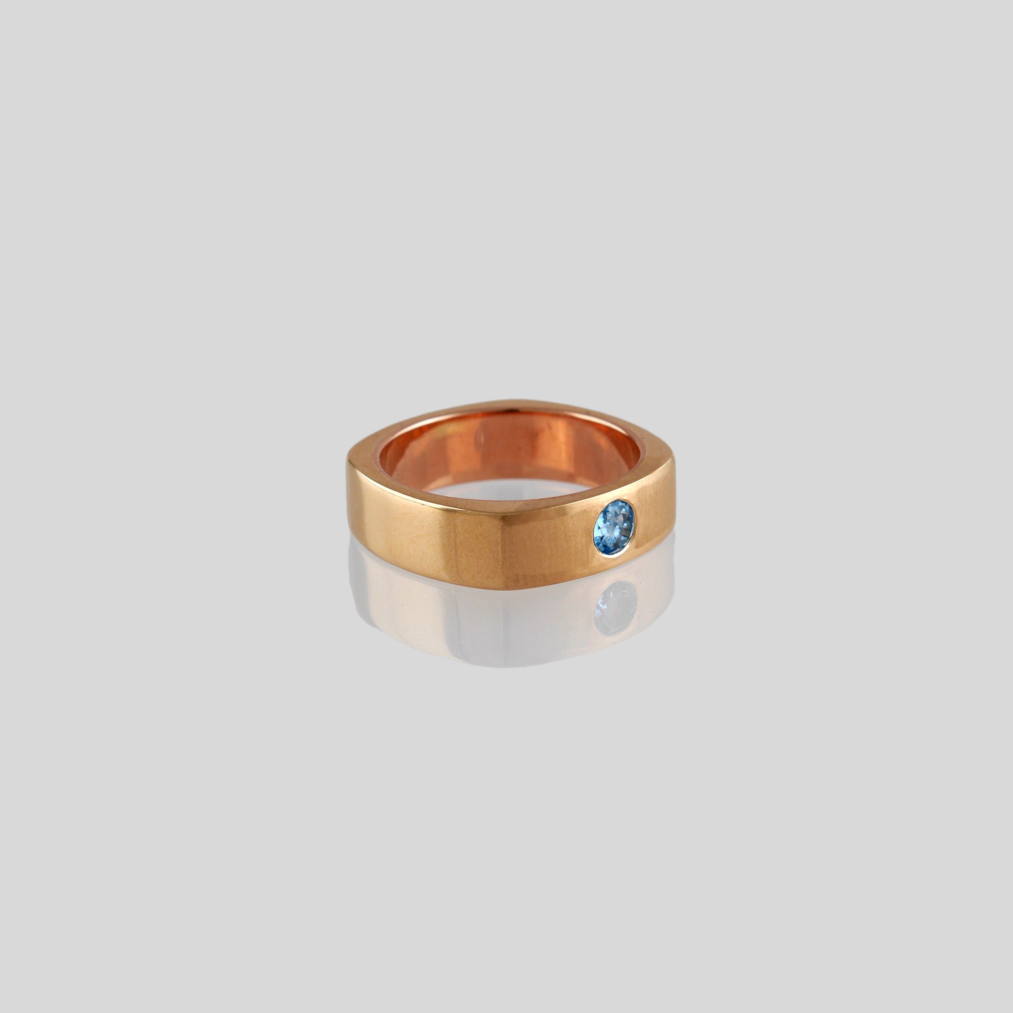 Square ring with rounded edges, symbolizing 'rounding the square,' crafted from 18k Rose Gold and adorned with Blue Topaz. A metaphor for overcoming challenges with grace and elegance.