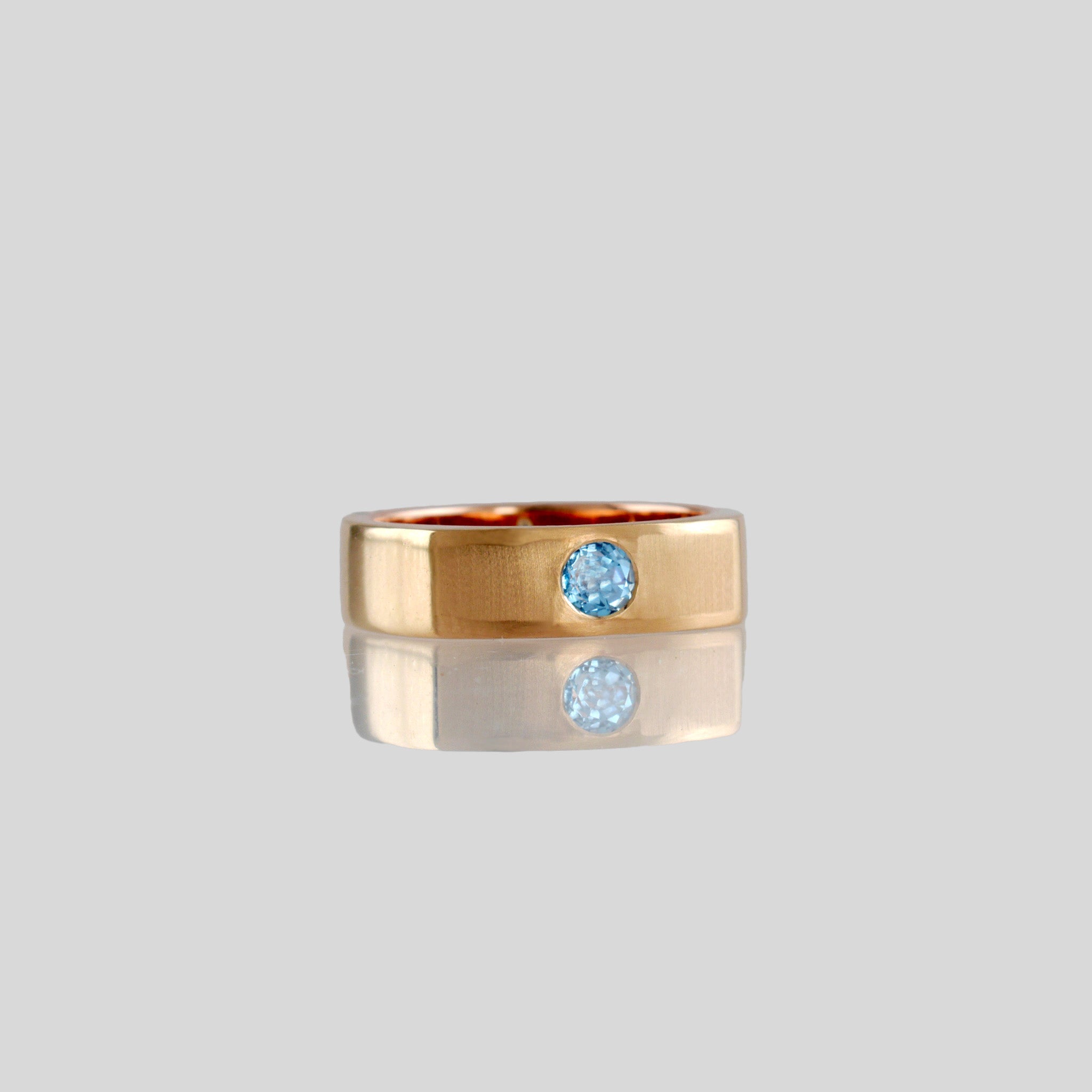 front view a Square Ring with rounded edges, symbolizing 'rounding the square,' crafted from 18k Rose Gold and adorned with Blue Topaz. A metaphor for overcoming challenges with grace and elegance.