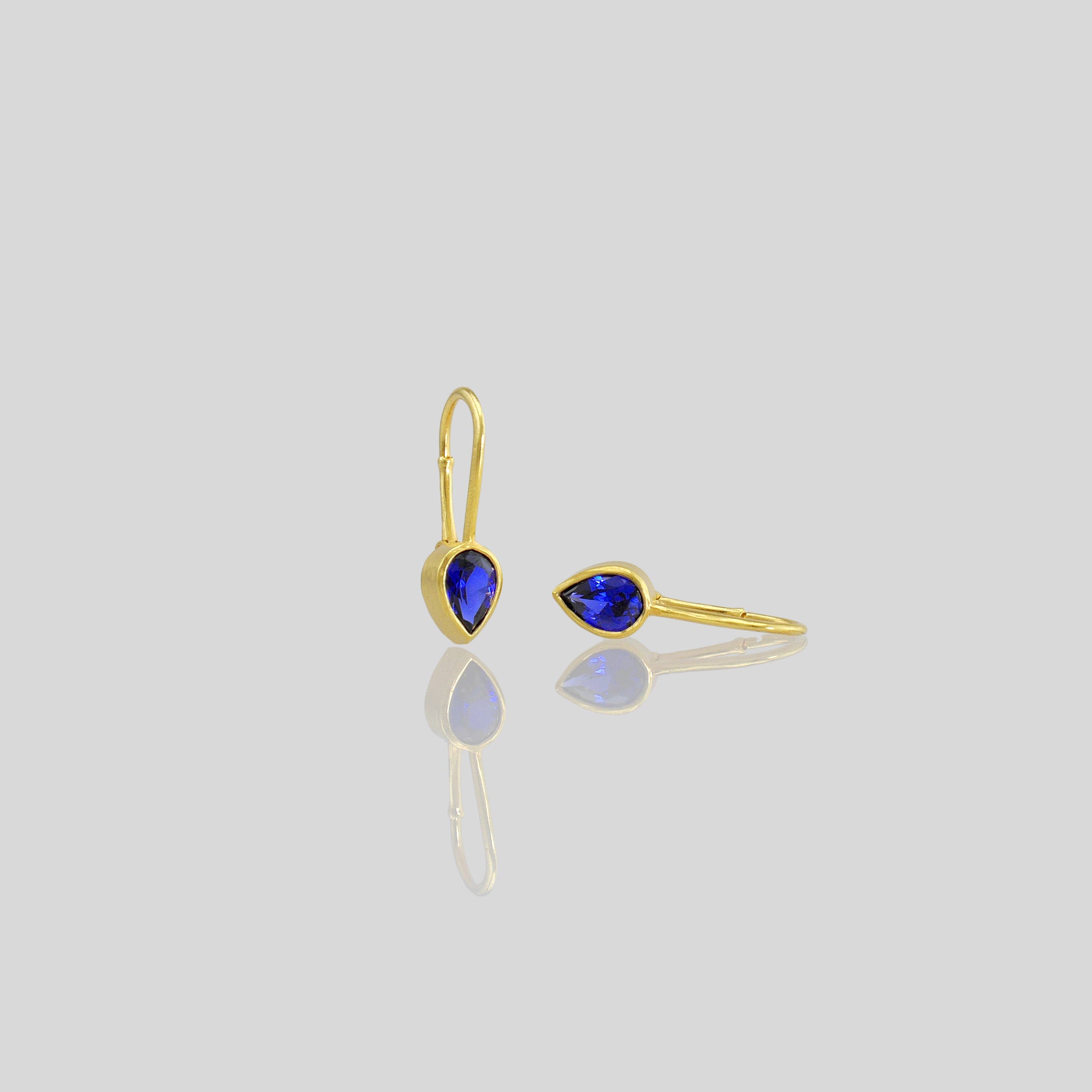 Lightweight gold earrings featuring a drop-shaped Sapphire gemstone and promote spiritual harmony