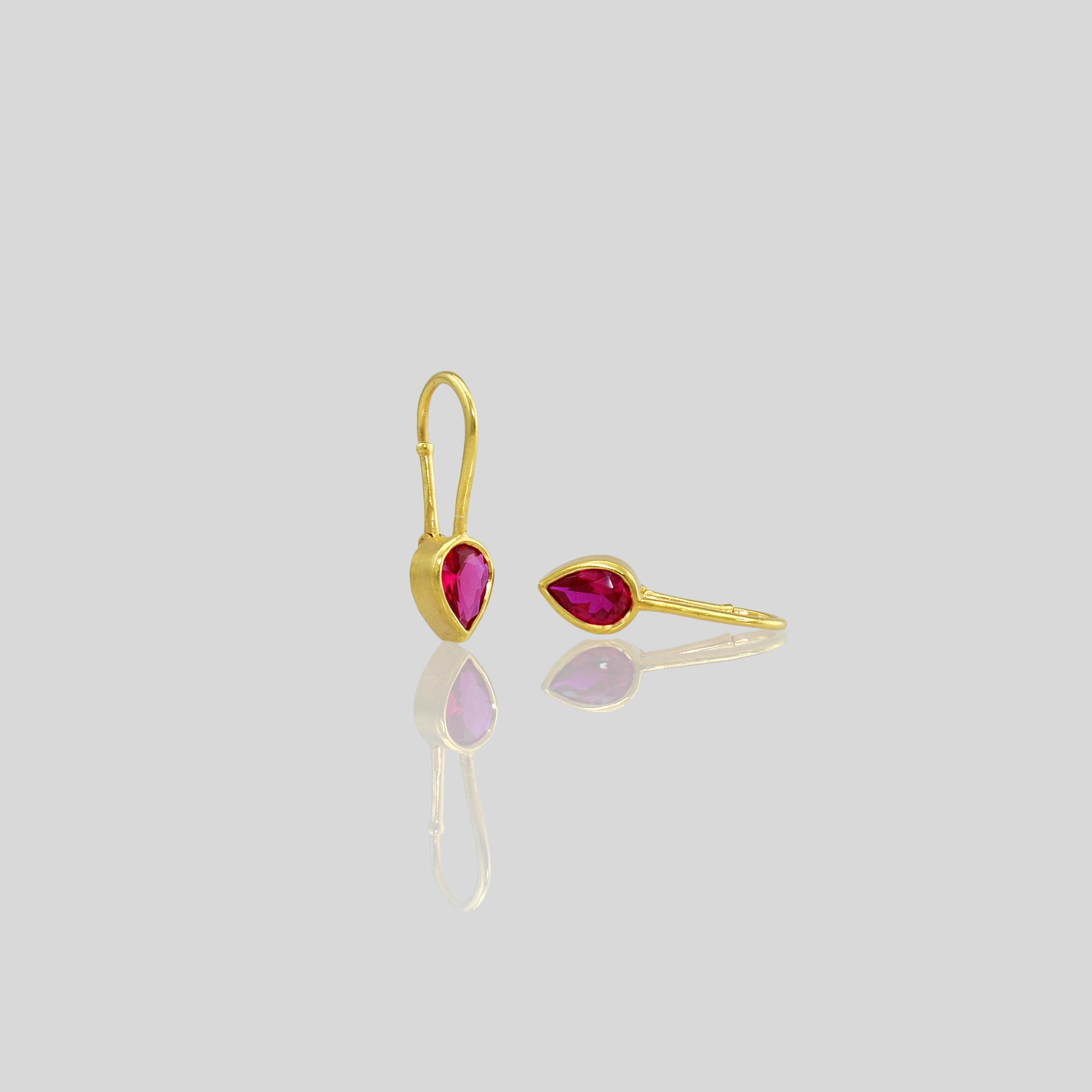 Lightweight gold earrings featuring  a drop-shaped Ruby gemstone and promote spiritual harmony 