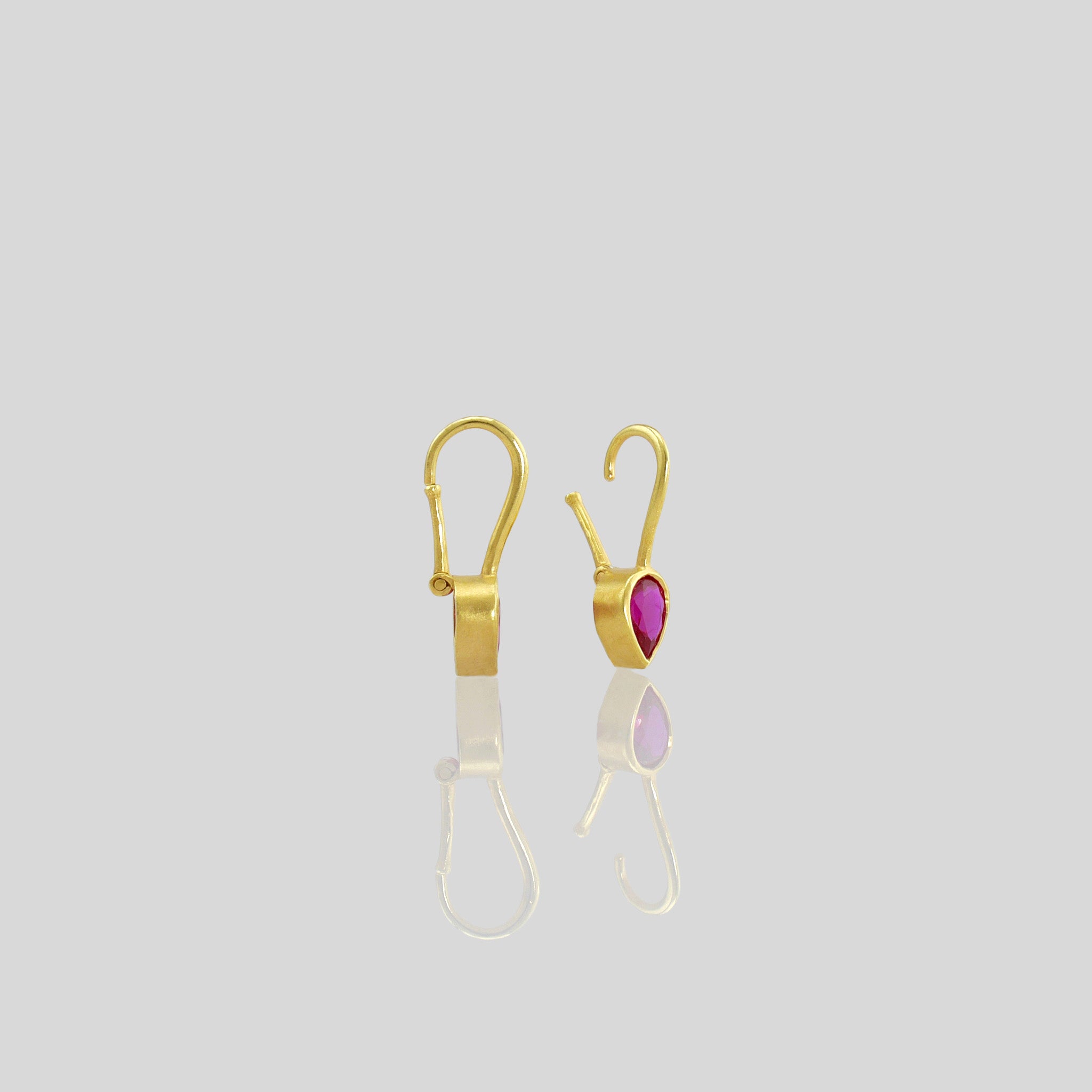 Lightweight gold earrings featuring a drop-shaped Ruby gemstone and promote spiritual harmony