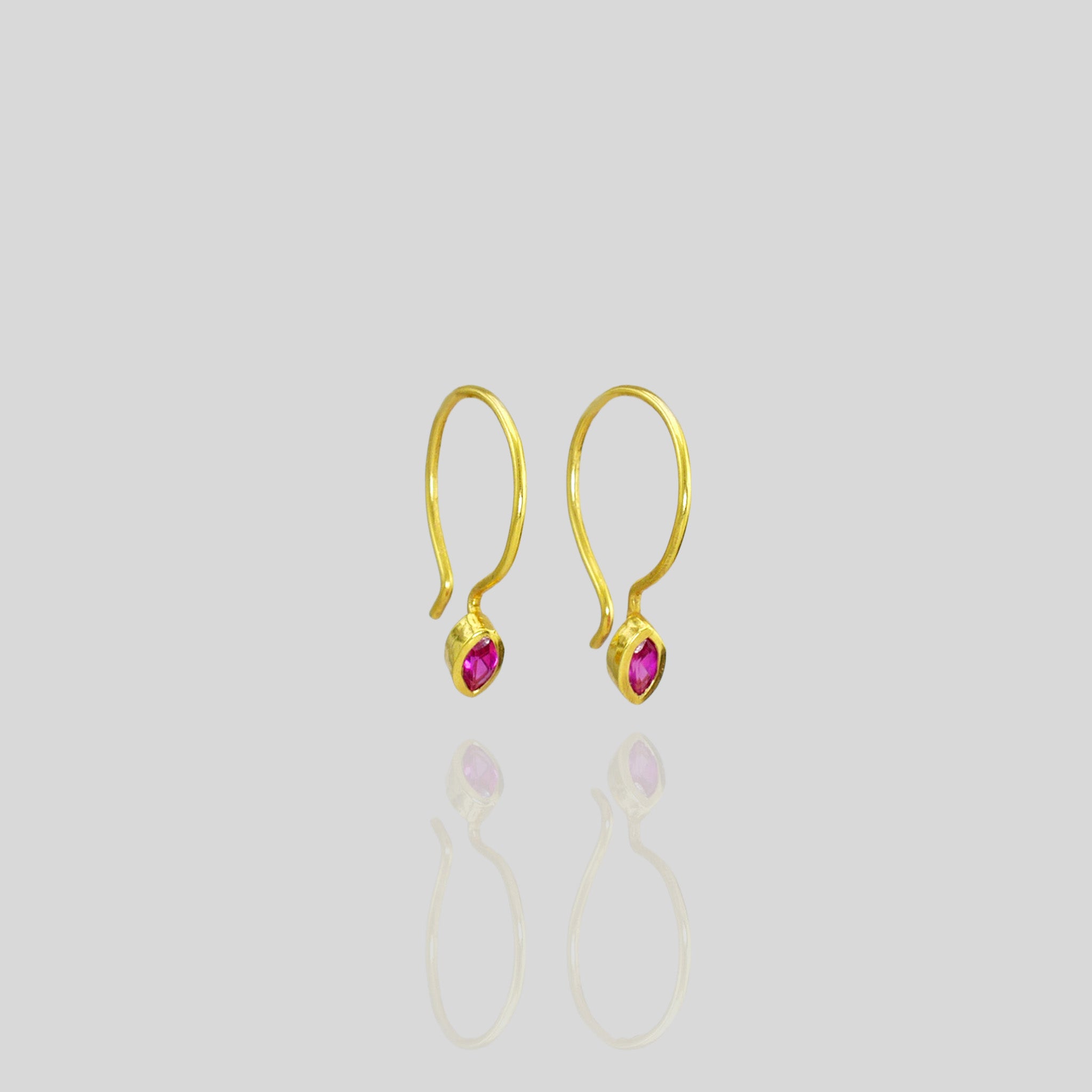 Close up of Tiny Ruby Marquee earrings on playful gold hoops. Elegant and eye-catching!