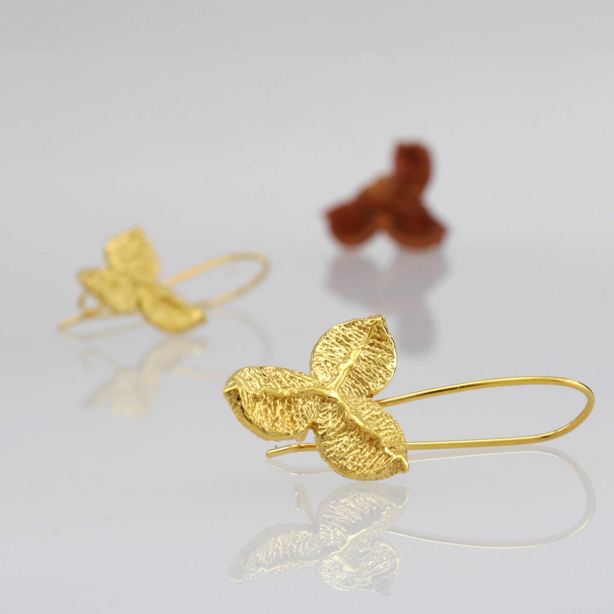 Close up of Nature-inspired Yellow Gold Drop Earrings with Unique Textured Design.