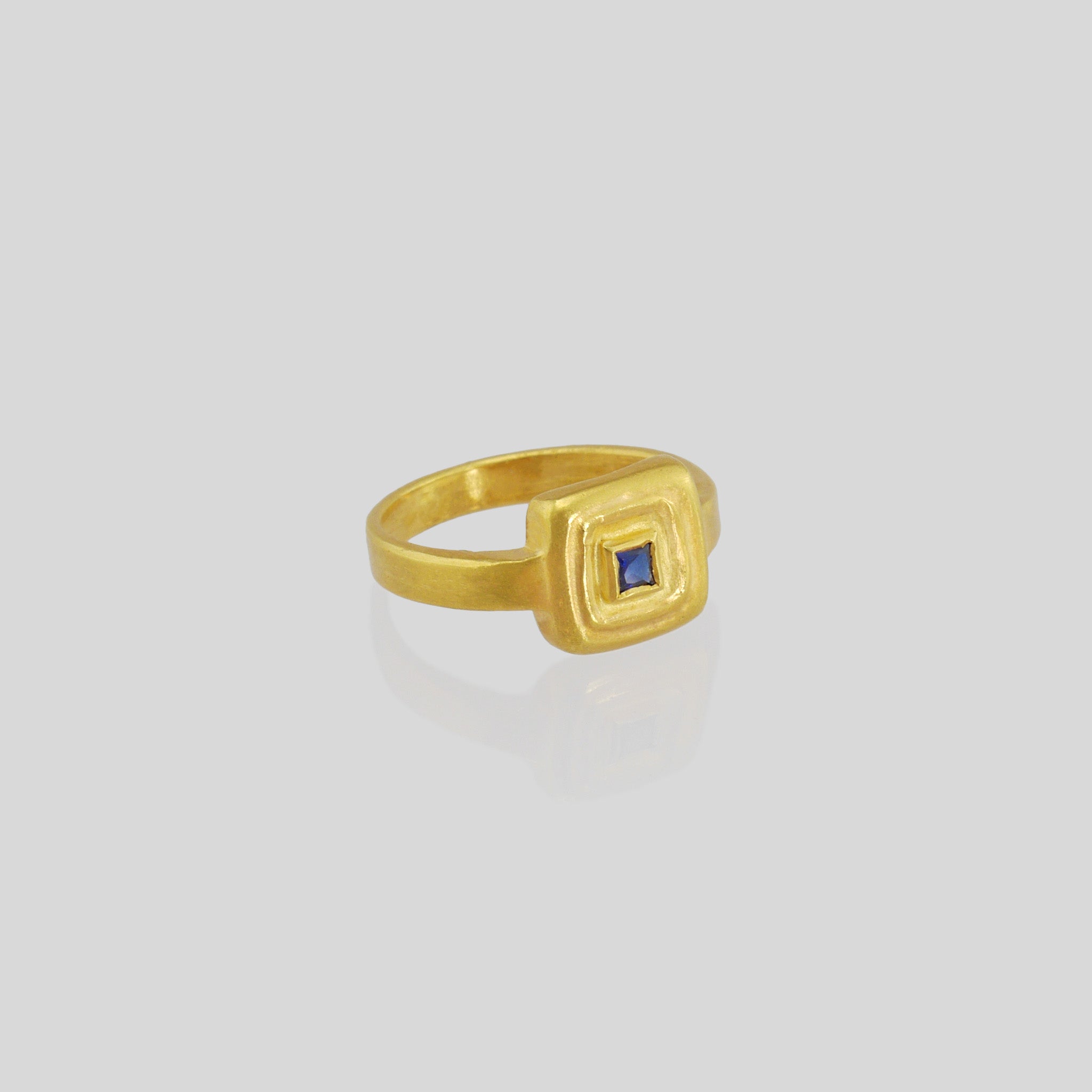 Handcrafted 18k Gold ring featuring a square Sapphire set atop a square surface, evoking the ancient Egyptian era's golden jewelry of the Pharaohs.