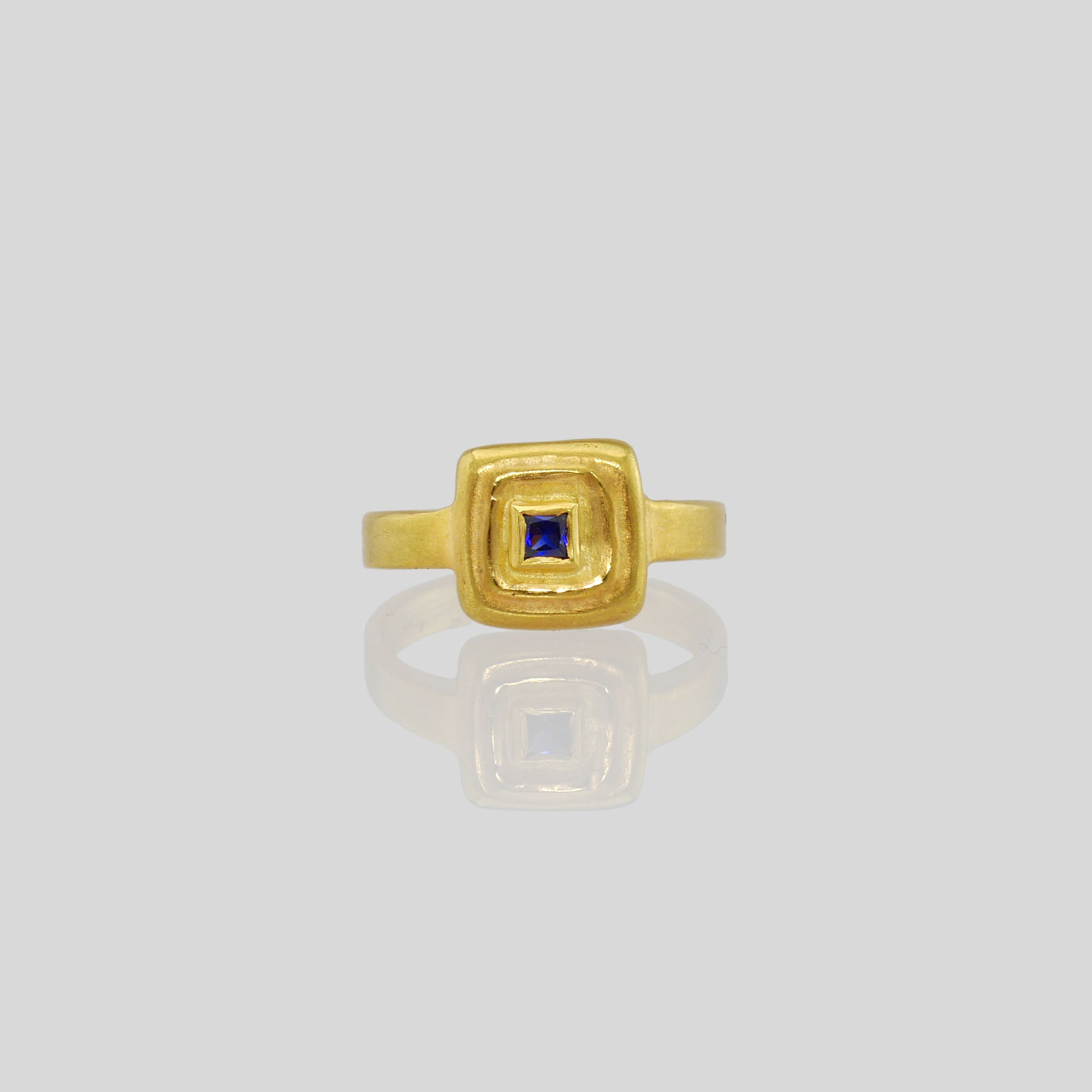 Front view of Handcrafted 18k Gold ring featuring a square Ruby set atop a square surface, evoking the ancient Egyptian era's golden jewelry of the Pharaohs.