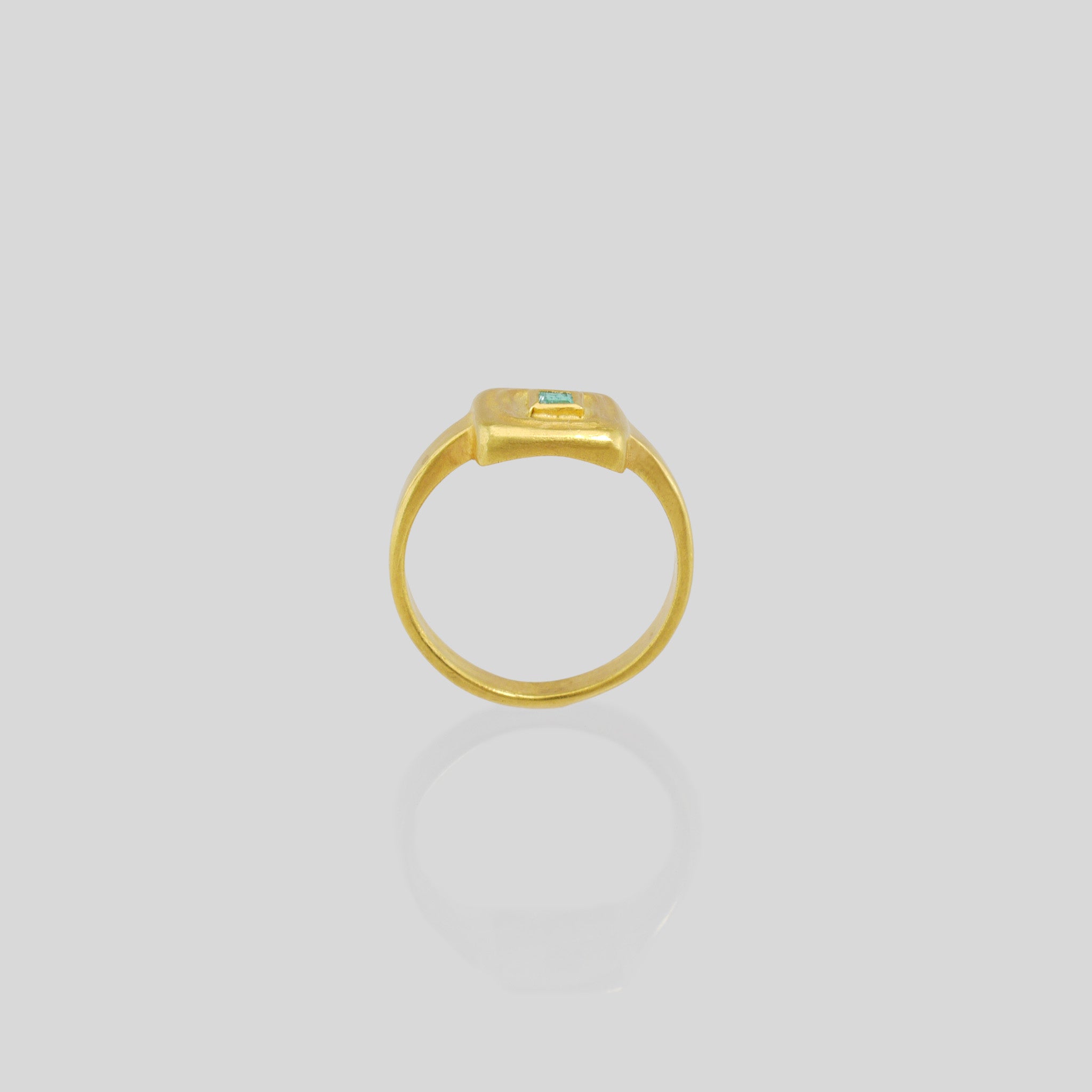 Side view of Handcrafted 18k Gold ring featuring a square Emerald set atop a square surface, evoking the ancient Egyptian era's golden jewelry of the Pharaohs.
