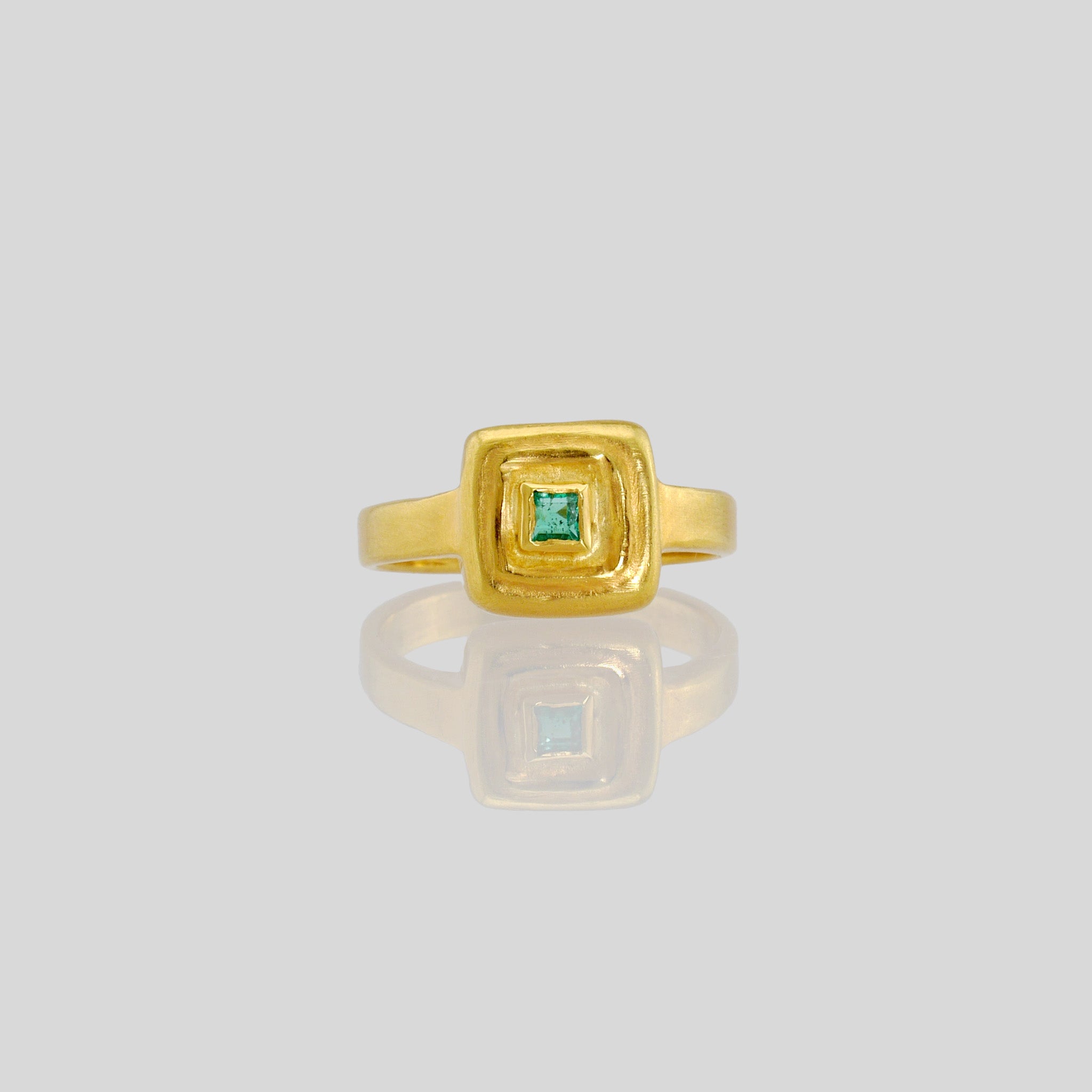 Front view of Handcrafted 18k Gold ring featuring a square Emerald set atop a square surface, evoking the ancient Egyptian era's golden jewelry of the Pharaohs.