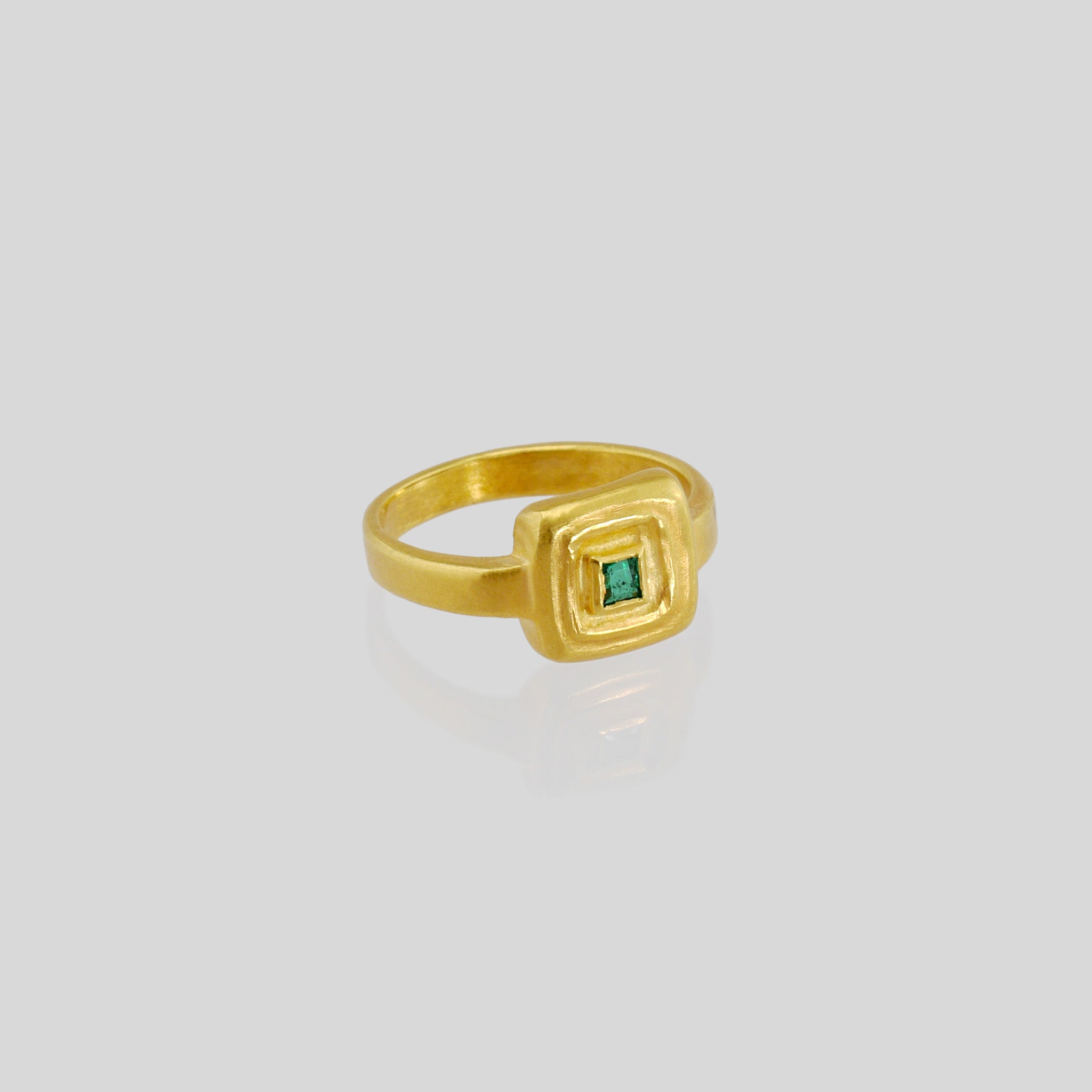 Handcrafted 18k Gold ring featuring a square Emerald set atop a square surface, evoking the ancient Egyptian era's golden jewelry of the Pharaohs.