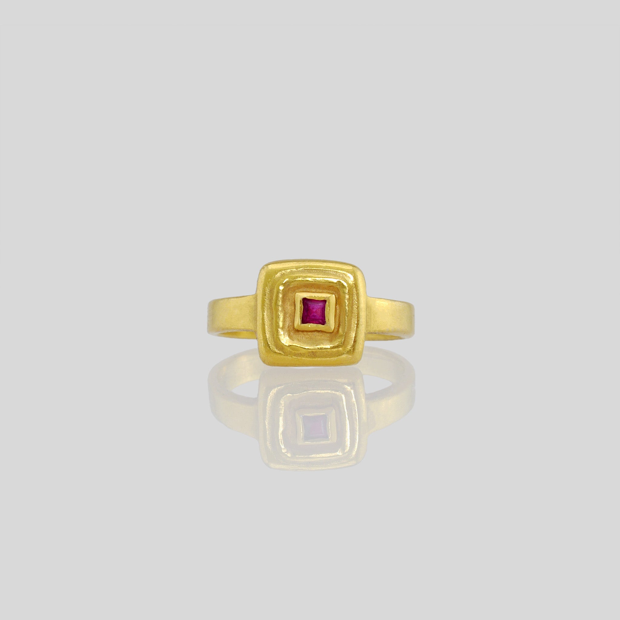 Front view of Handcrafted 18k Gold ring featuring a square Ruby set atop a square surface, evoking the ancient Egyptian era's golden jewelry of the Pharaohs.