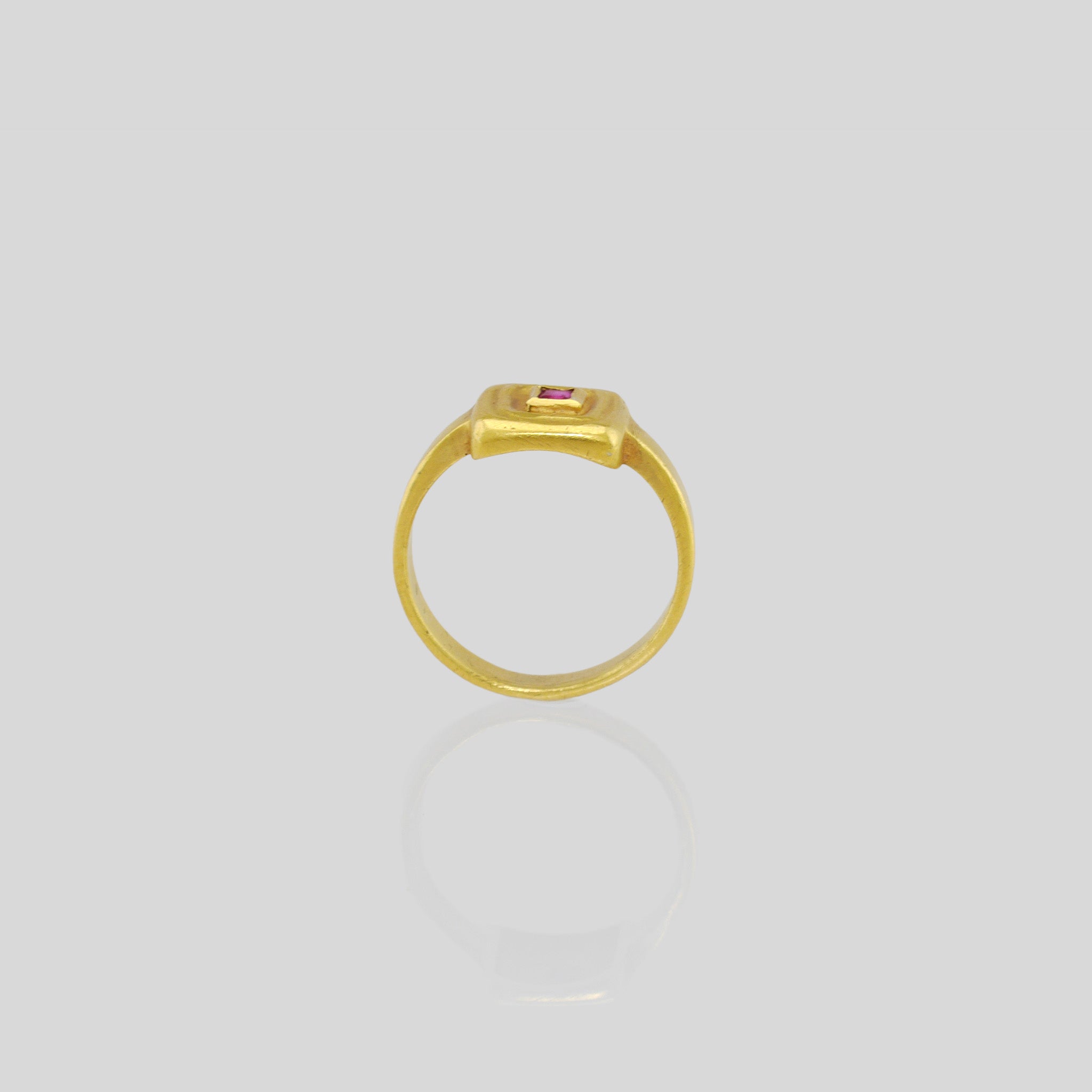 side view of Handcrafted 18k Gold ring featuring a square Ruby set atop a square surface, evoking the ancient Egyptian era's golden jewelry of the Pharaohs.