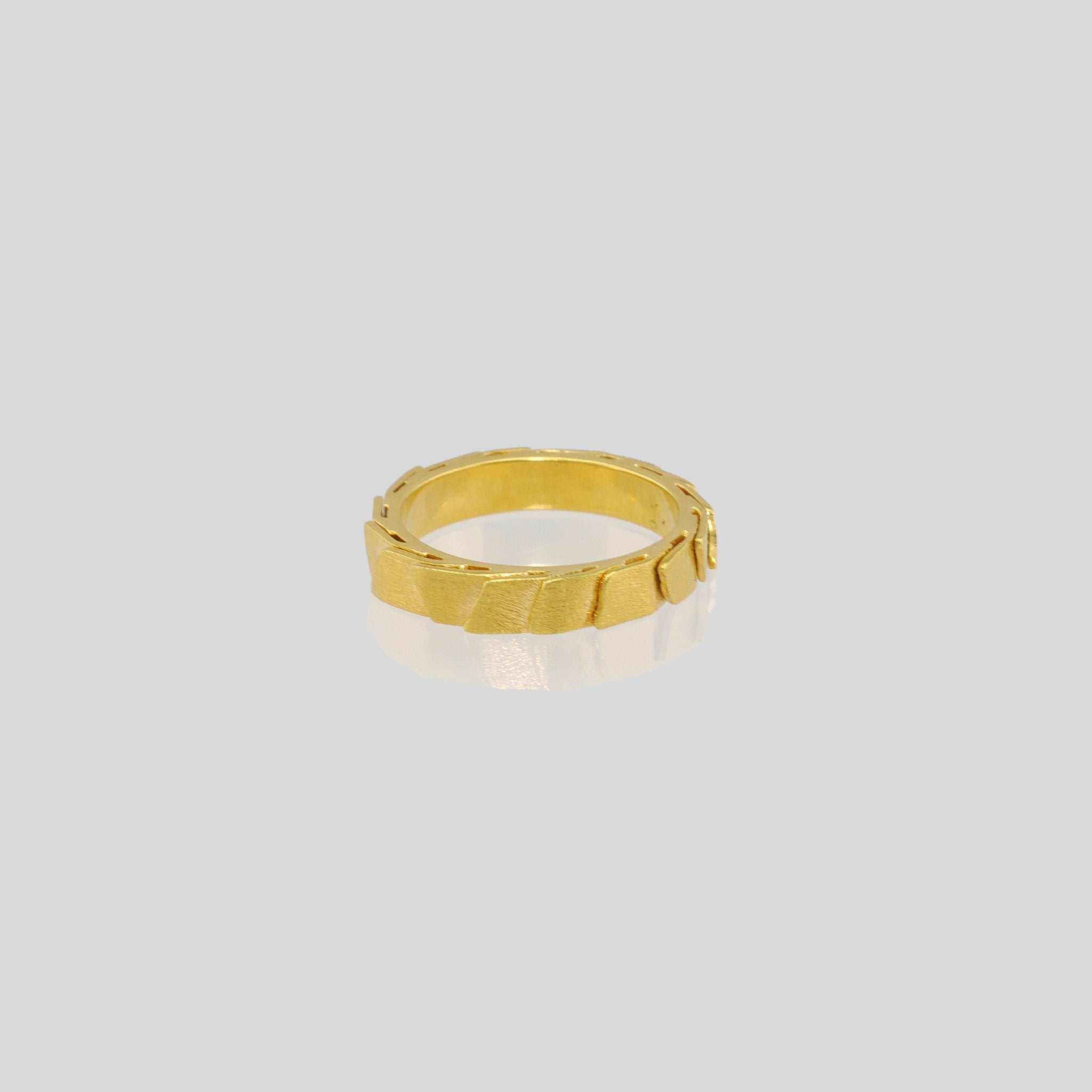 A captivating gold ring adorned with overlapping layers, evoking a sense of continuous motion and embrace. The inner surface is smooth, for optimal comfort.