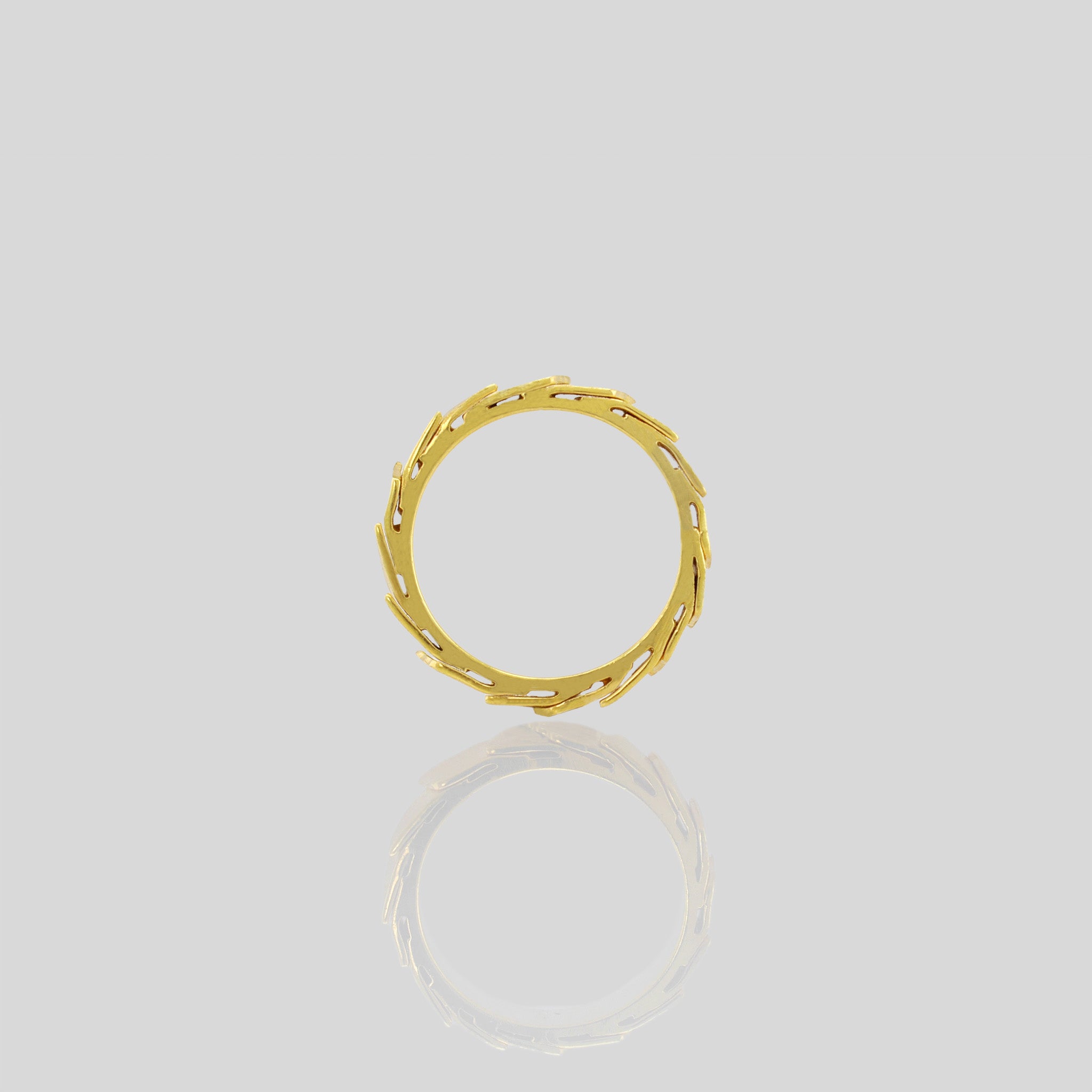 Side view of A captivating gold ring adorned with overlapping layers, evoking a sense of continuous motion and embrace. The inner surface is smooth, for optimal comfort.
